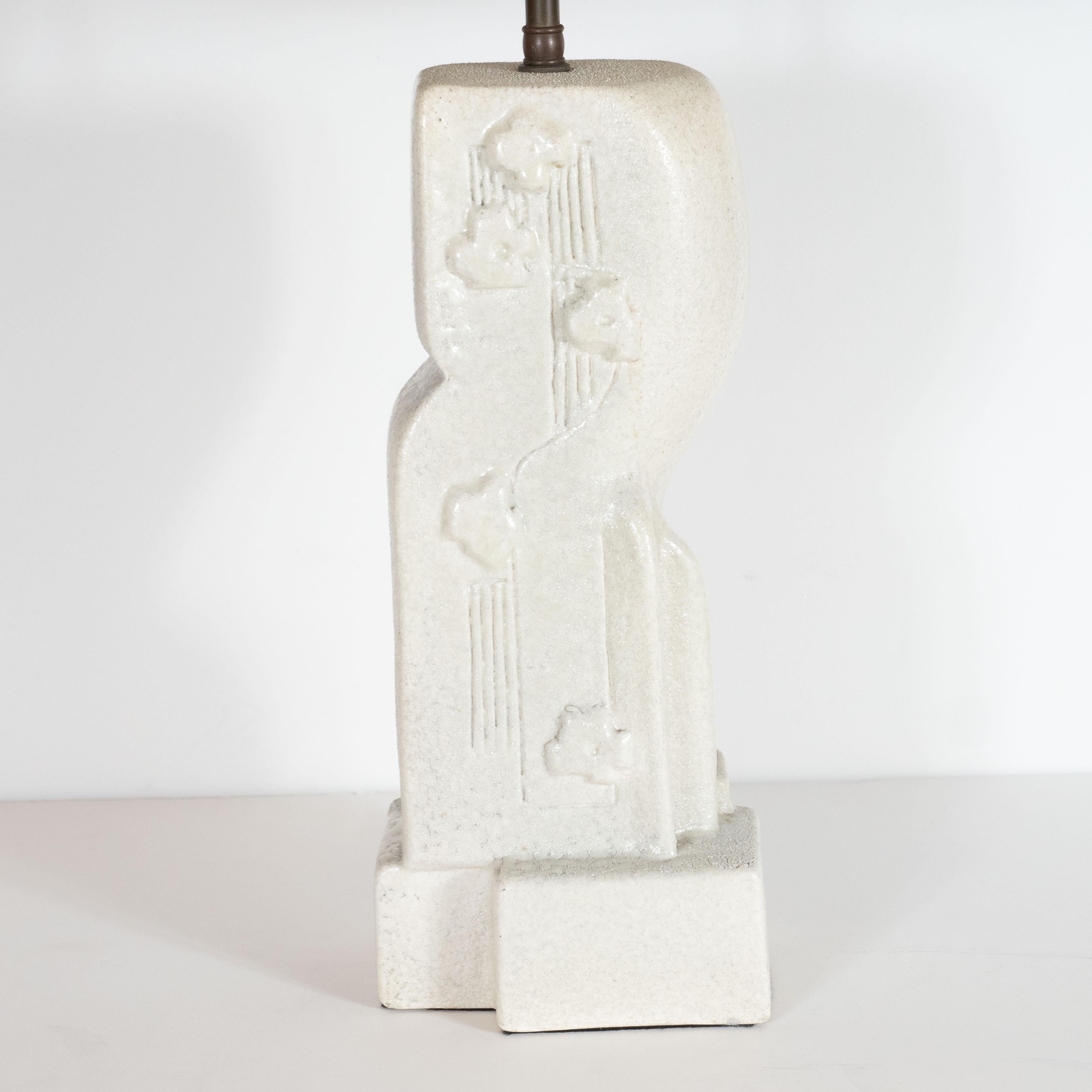 This elegant table lamp was realized by the esteemed designer Mariana von Allesch, circa 1950. It features stylized amorphic and asymmetrical design with striated channel detailing and cubist motifs in relief adorning the facade of the piece. The