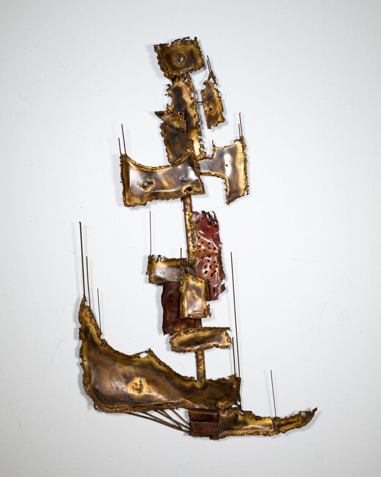 An abstract brutalist metal wall sculpture from Curtis Jere. This naval inspired abstract sculpture sits boldly on any wall with its iconic brutalist design. It is in very good vintage condition. This piece measures 37 in high, 21.5 in wide, and
