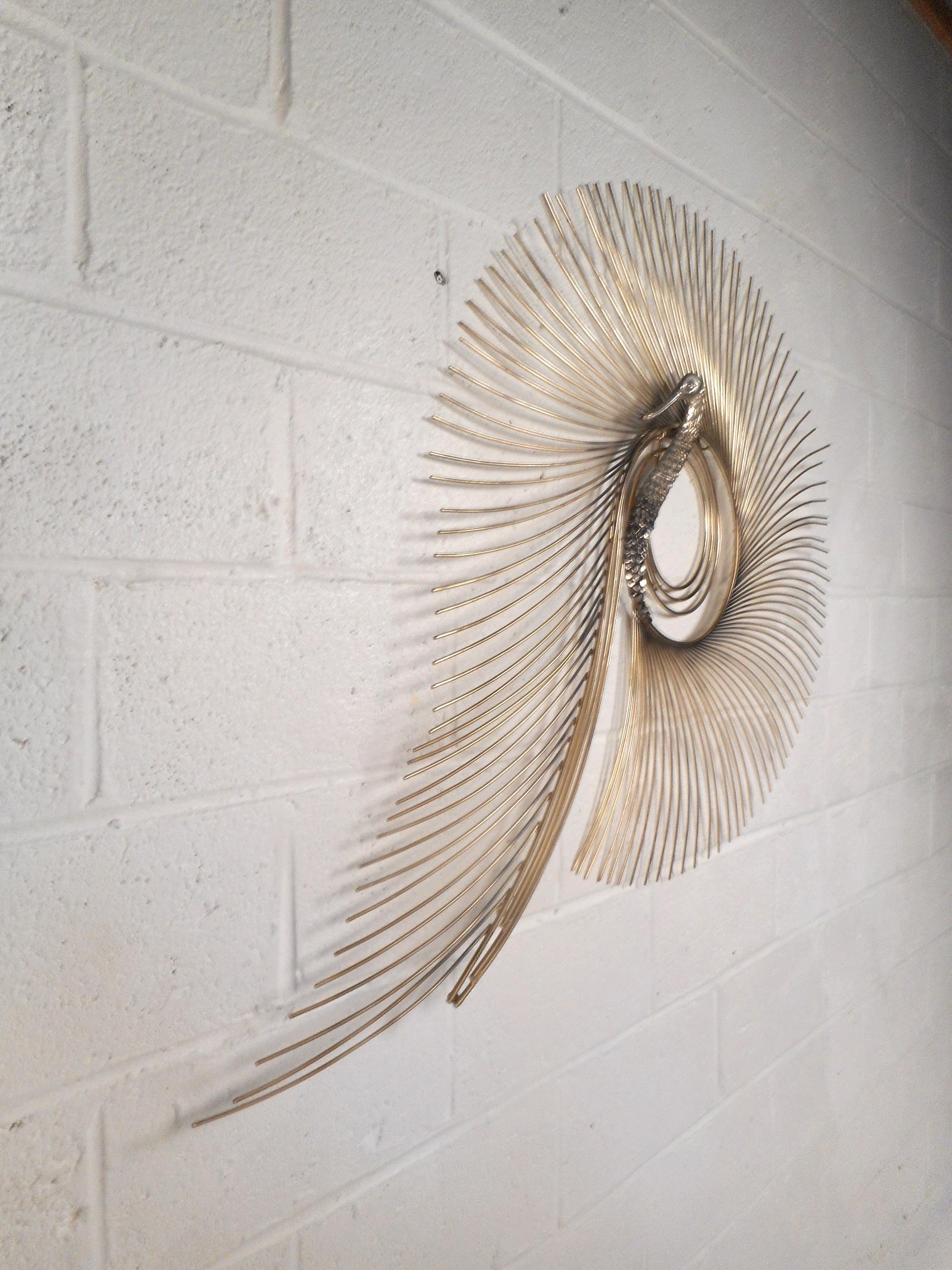 This stunning vintage modern three dimensional wall art features a polished brass body with thick rods creating a spiraling design around it. A wonderful peacock sculpture with intricate detail signed by C. Jere and dated 1987. This unusual and