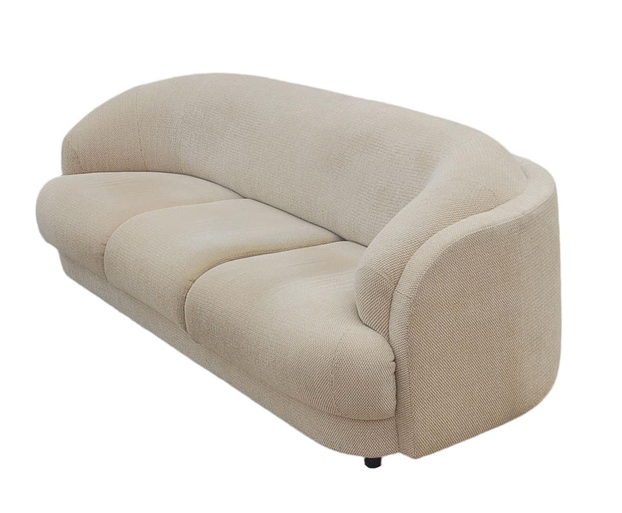 A rounded back stylish sofa from 1980s in the style of Milo Baughman. This sofa is super comfortable with low profile black legs to give it a low floating appearance. Fabric is soiled from age, so professional cleaning or recovering is recommended.