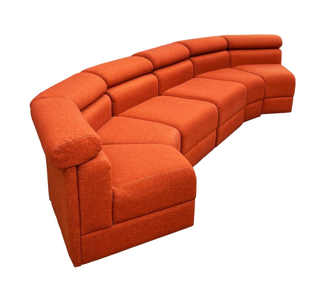 Ein sechsteiliges modulares Sofa um 1970. Diese sind mit ihrem ursprünglichen orangefarbenen Wollstoff ausgestattet. In brauchbarem Zustand, würde aber mit neuem Stoff gut aussehen. 

Wir haben 2 passende Sofas auf Lager. Jedes Set enthält 4