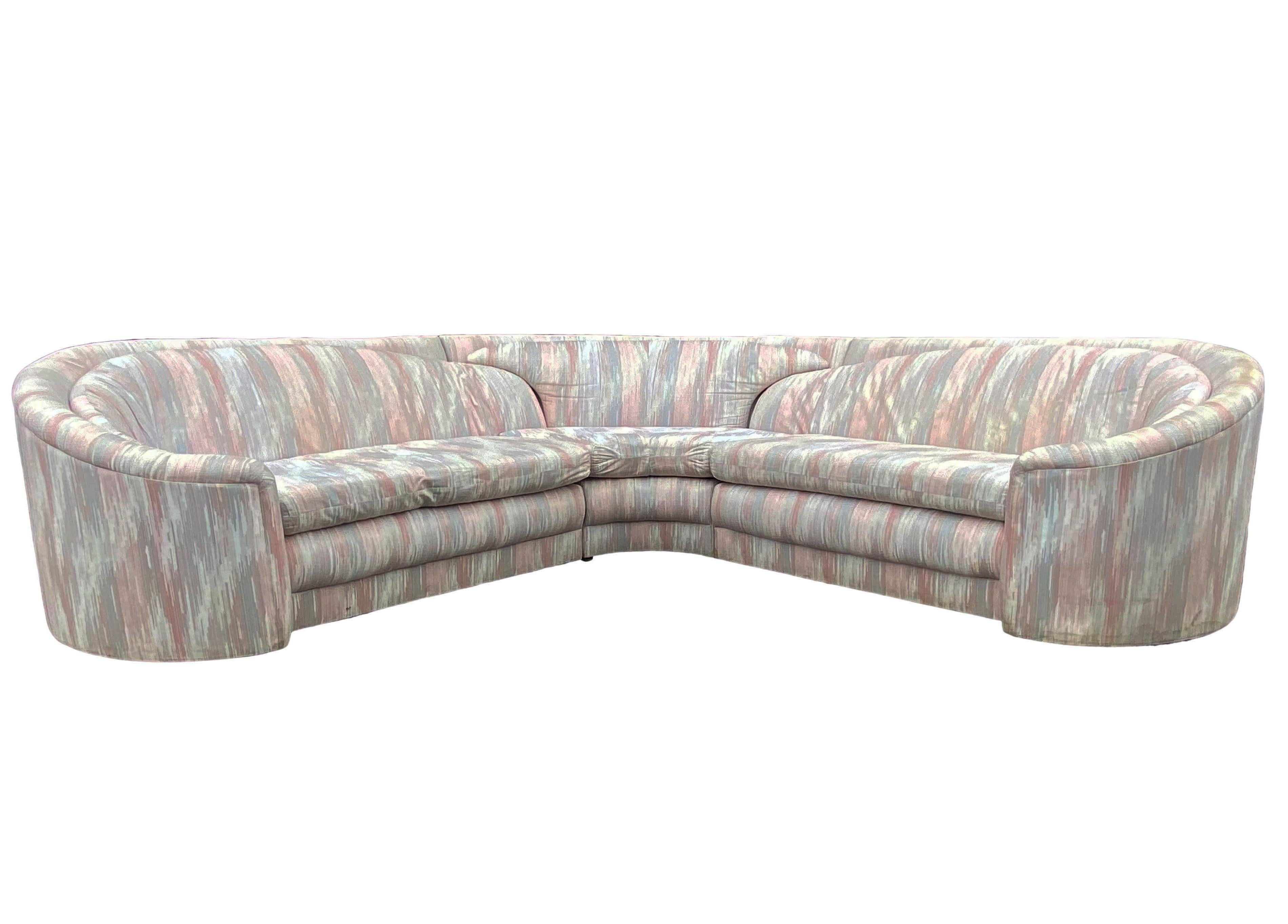 A curvy three piece sectional designed by Carson's Furniture and produced in the early 1980s. It features a unique over lapping cushion design. Fabric is original, and dated, but usable if desired. Manufacture labels.