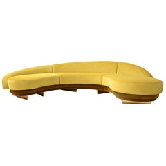 Canapé moderne en serpentin incurvé en velours jaune avec détails en bois et or