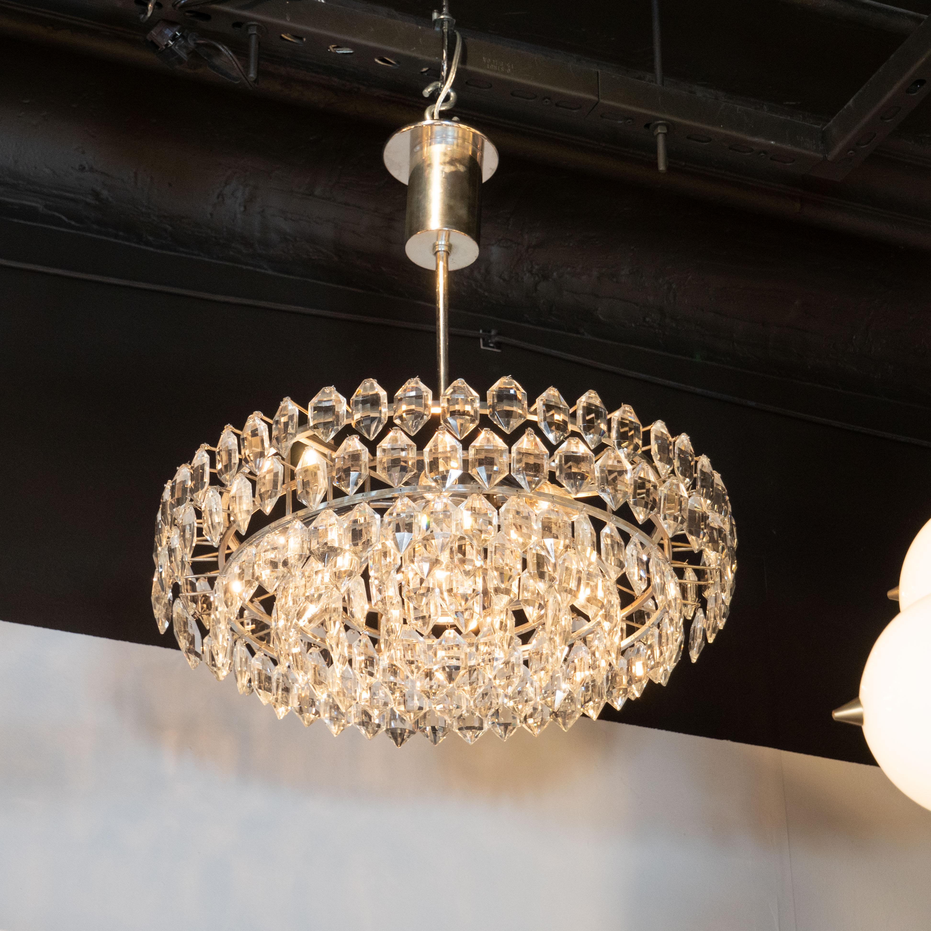 This elegant and refined Mid-Century Modern chandelier was realized by the esteemed Austrian atelier, Bakalowits and Sohne, circa 1960. It features five tiers of cut and beveled crystal- resembling rows of brilliant white diamonds- consisting of