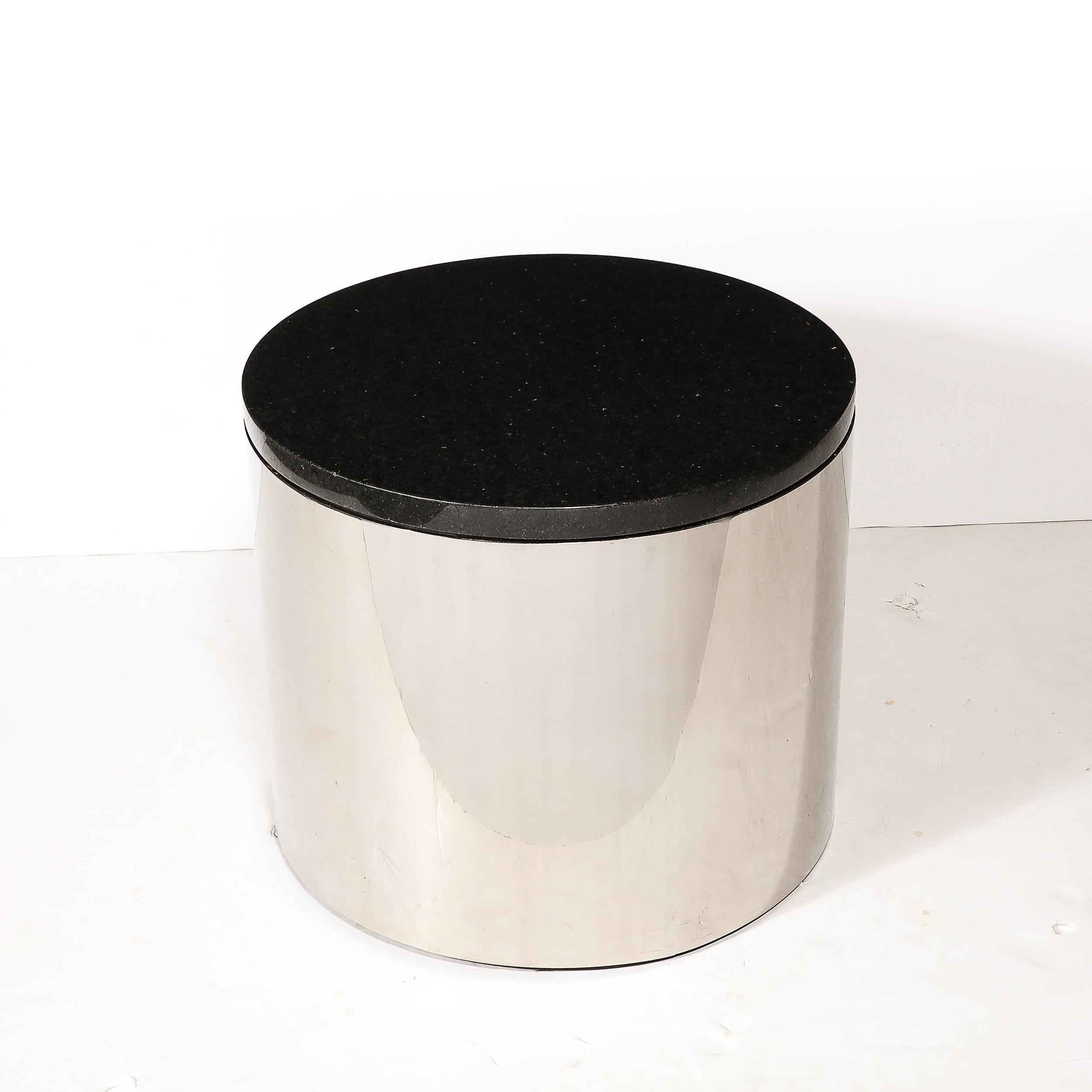 Cette table d'appoint raffinée de style moderne du milieu du siècle en forme de tambour cylindrique en chrome et granit a été réalisée aux États-Unis, vers 1970. Il se compose d'un corps cylindrique en chrome brillant et d'un plateau rond en granit.