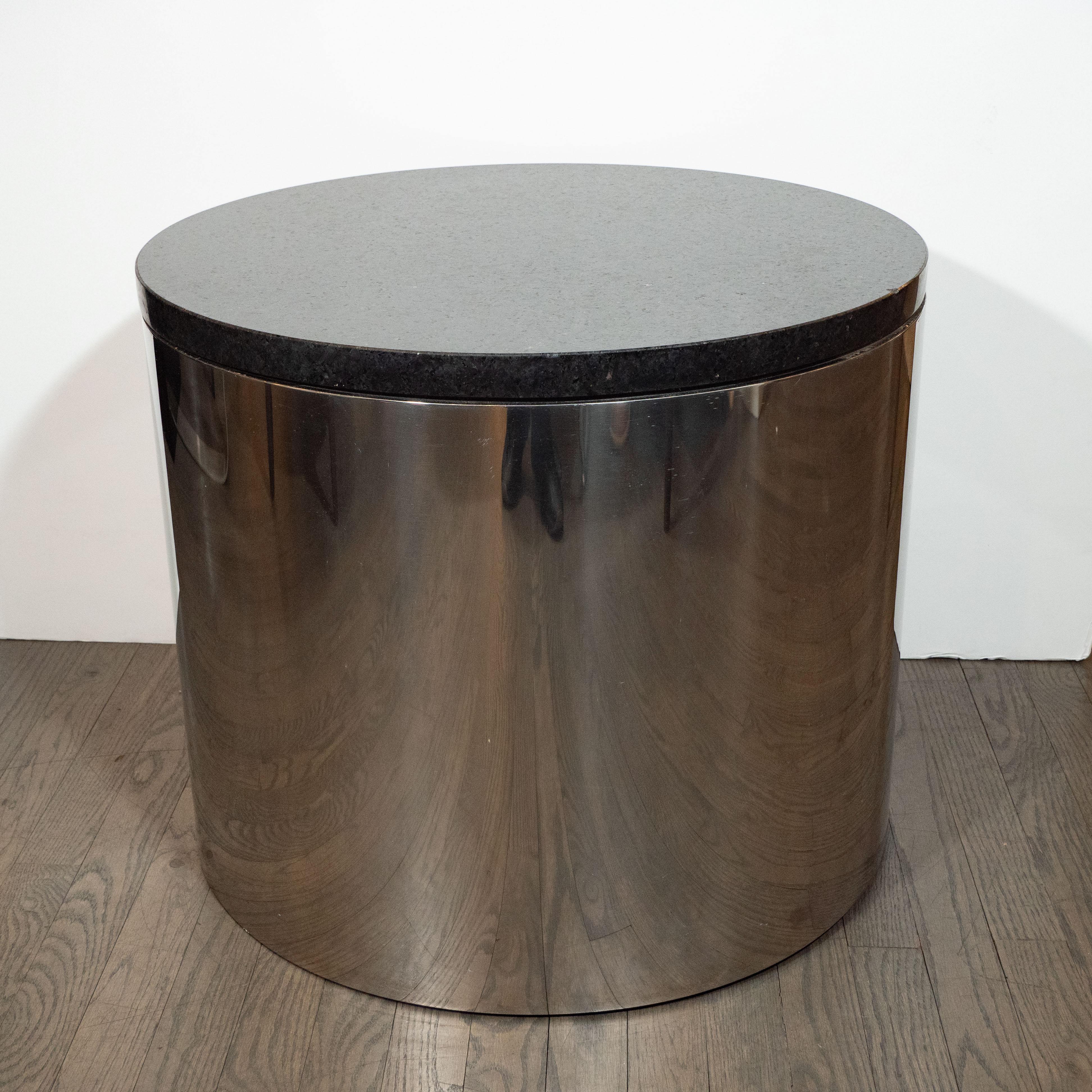 This refined occasional table was realized in the United States, circa 1970. It features a cylindrical body created from lustrous chrome with a circular granite top. The piece is a study in the simple beauty of excellent design- minimal,