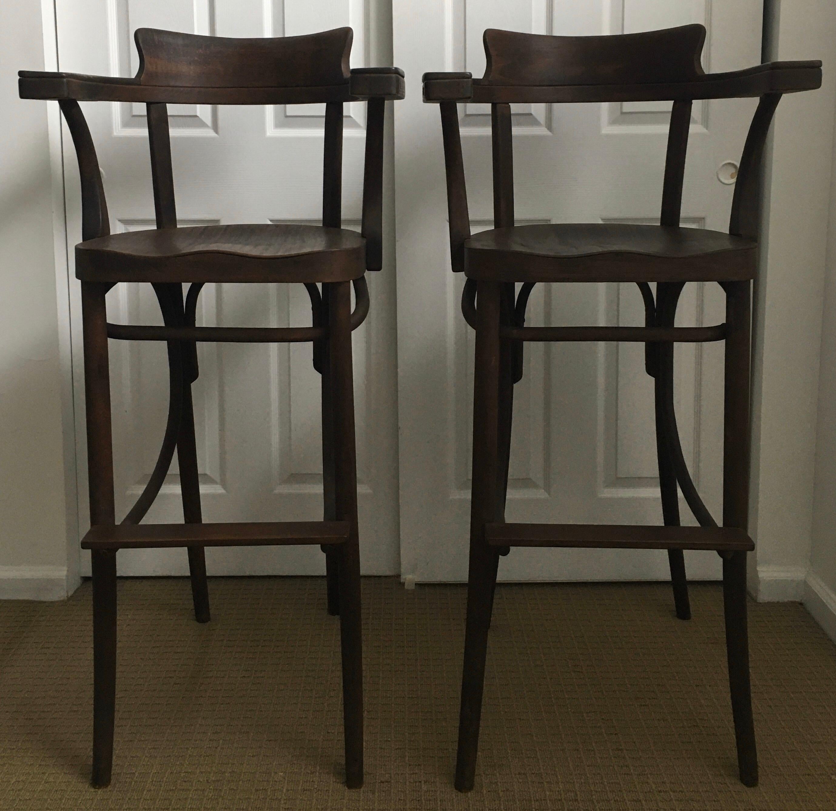 Set of two rare Czechoslovakian Mid-Century Modern Bentwood tall barstools. Sleek and sculptural bentwood Thonet style wood frames with original dark walnut finish patina. Features comfortable hand carved seats and arm rests. 

Made in