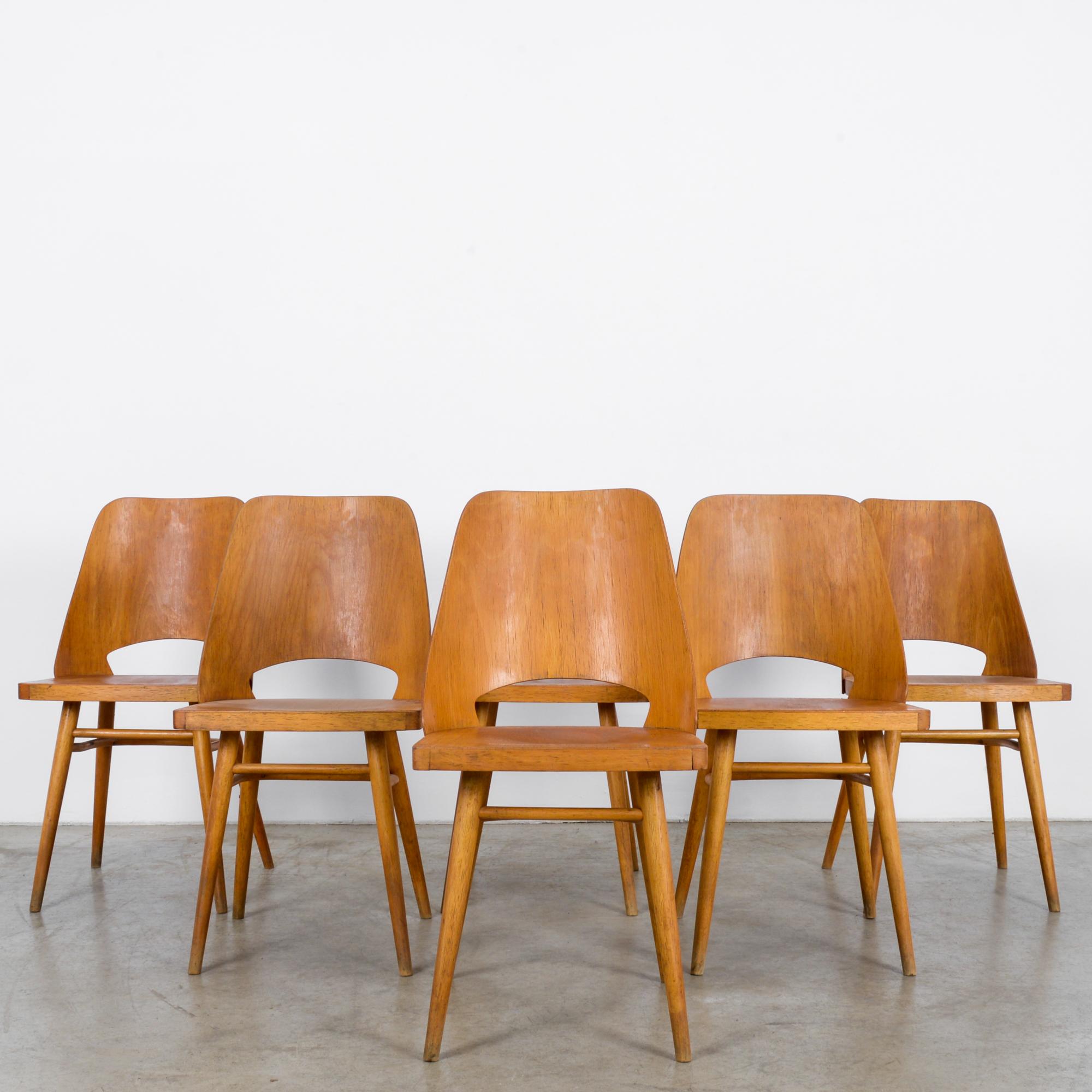 This set of six wooden chairs was made in the former Czechoslovakia, circa 1960. The chairs have a refined structure accentuated by the curves of the back and rear stretcher. Supported on tapered and splayed legs, the chairs display a polished