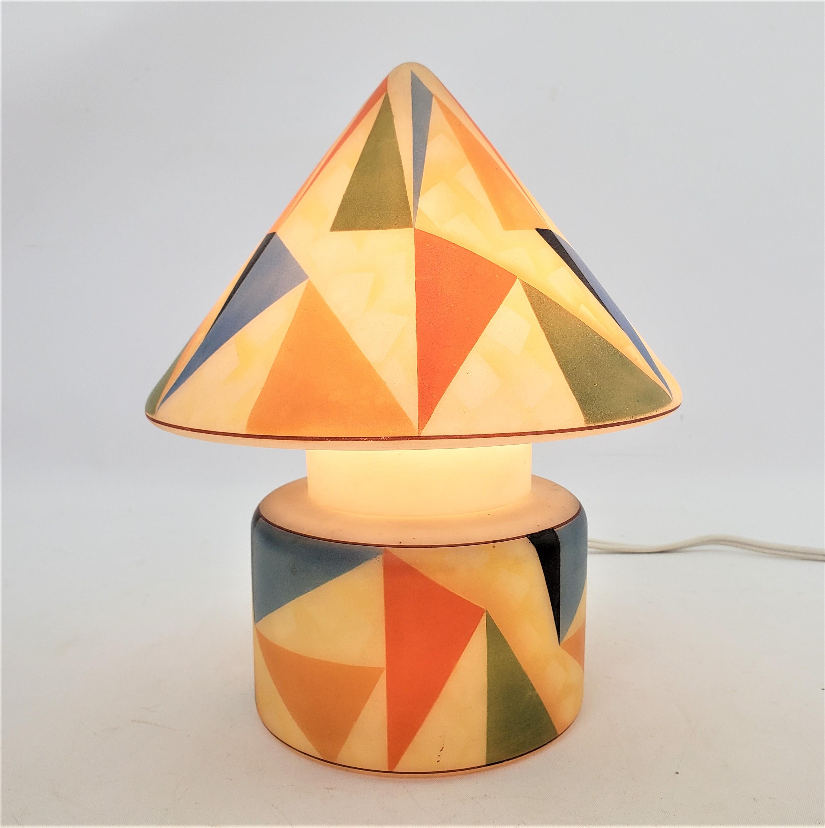 This glass accent or table lamp is unsigned, but presumed to have originated from the Czech Republic and date to approximately 1960 and done in the period Mid-Century Modern style. The lamp is done with a conical shaped shade and a squat cylindrical