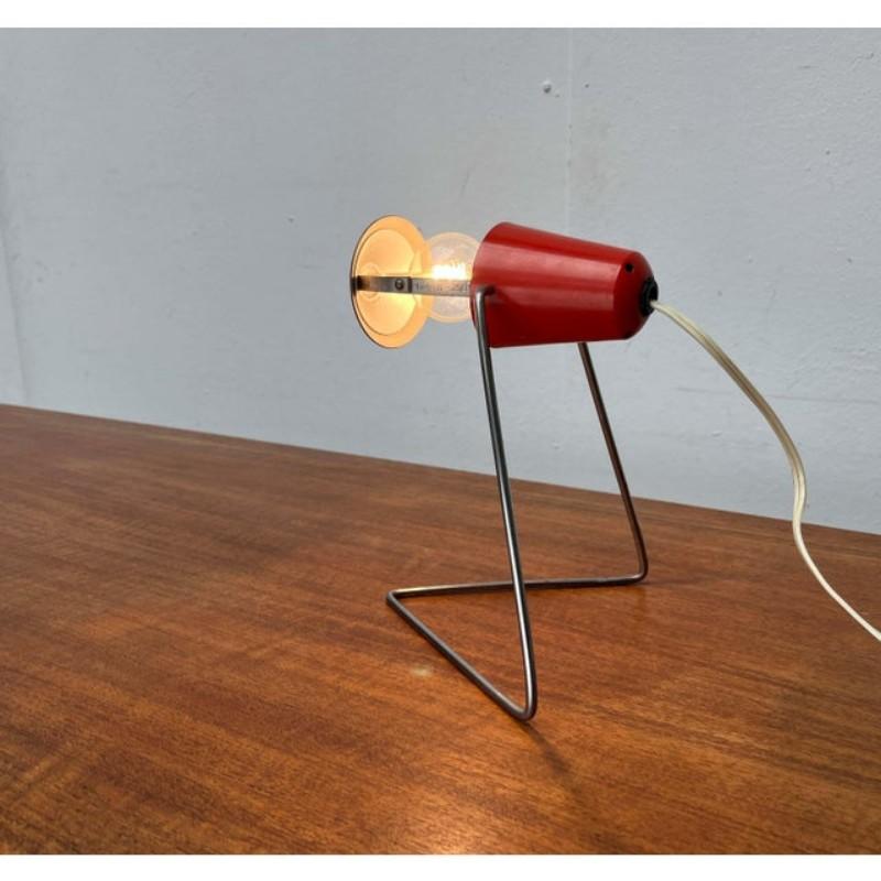 Mid-century table or wall lamp by the Czech manufacturer Okolo, based on a design by Helena Frantova from the 1960s.

Small table lamp with a distinctive base. This base is enclosed in a dirty metal bracket. The lamp body is clamped into the base