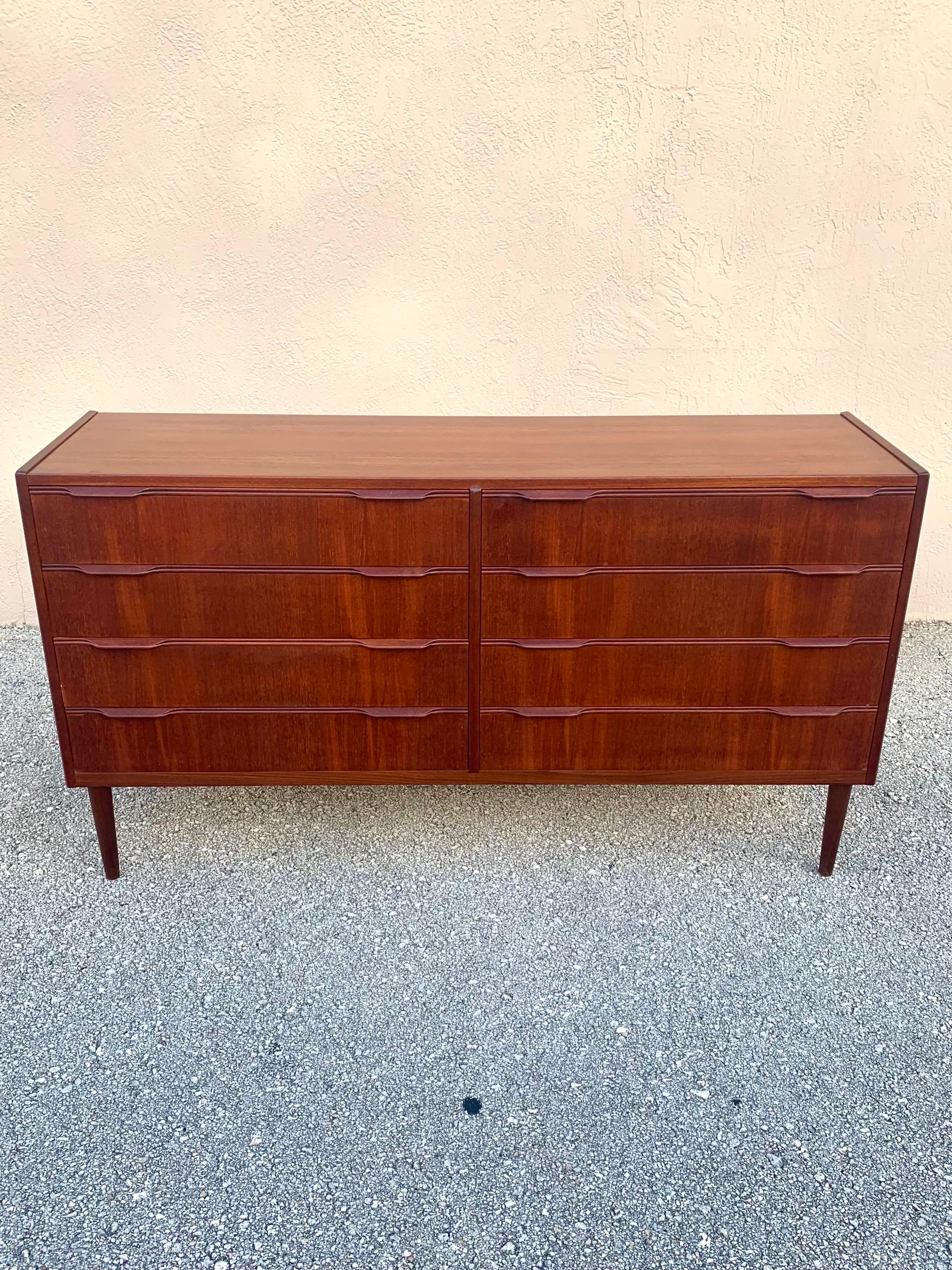 8 drawer teak Double dresser. Made in Denmark in the 1960s. Gorgeous veneer showing the lovely grain of the teak. Exceptionally carved solid teak drawer pulls and details. Unsure if ever refinished. The color looks as if it is the original finish.