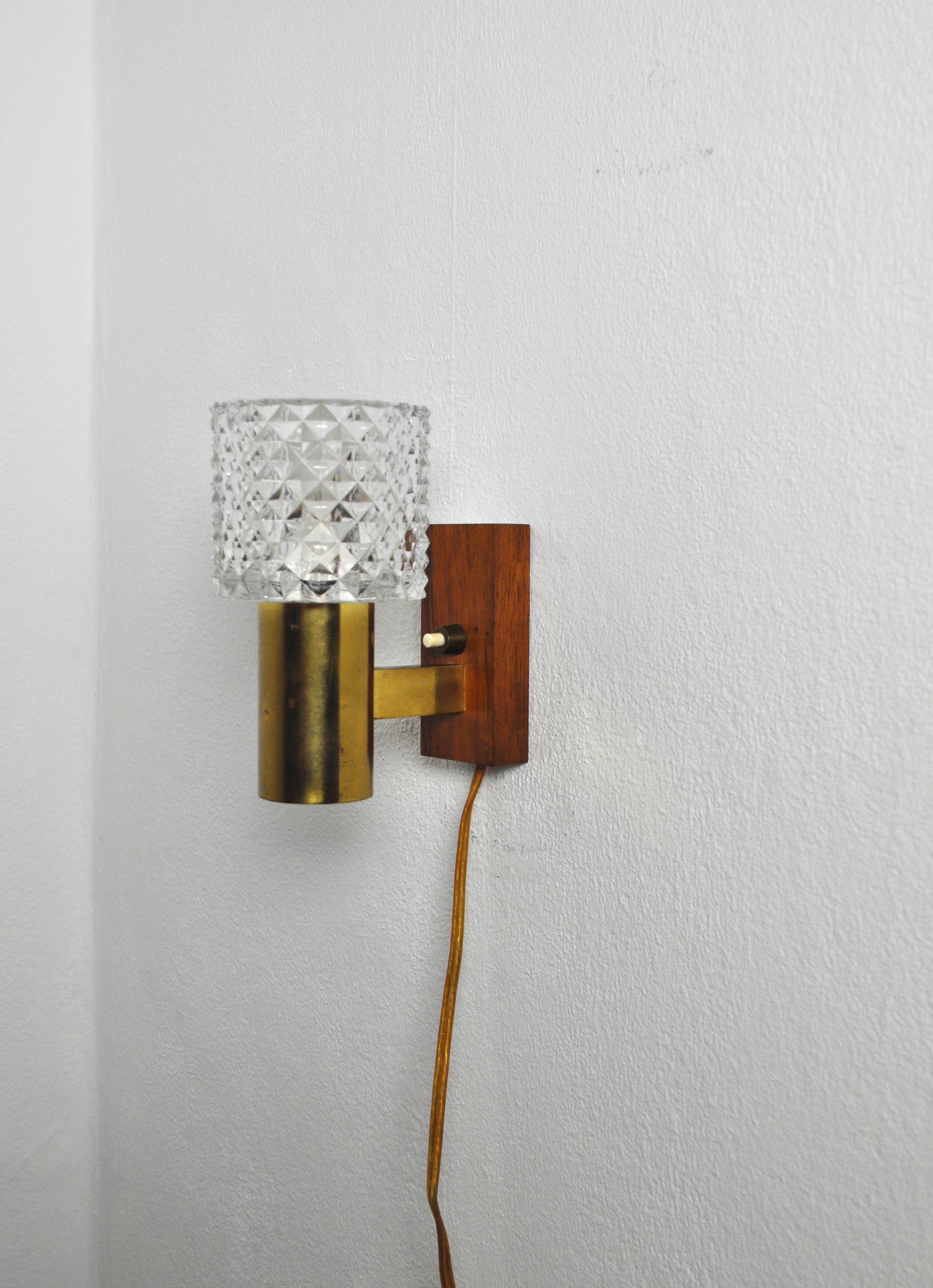 Mid-Century Modern wall light in solid teak, brass and glass shade. 
Probably made in Denmark the 1960s.
Very good vintage condition.

Dimensions:
Height 14.5 cm
Width 8.5 cm
Depth 13.5 cm
Glass shade: diameter 8.5 cm, height (visible part):