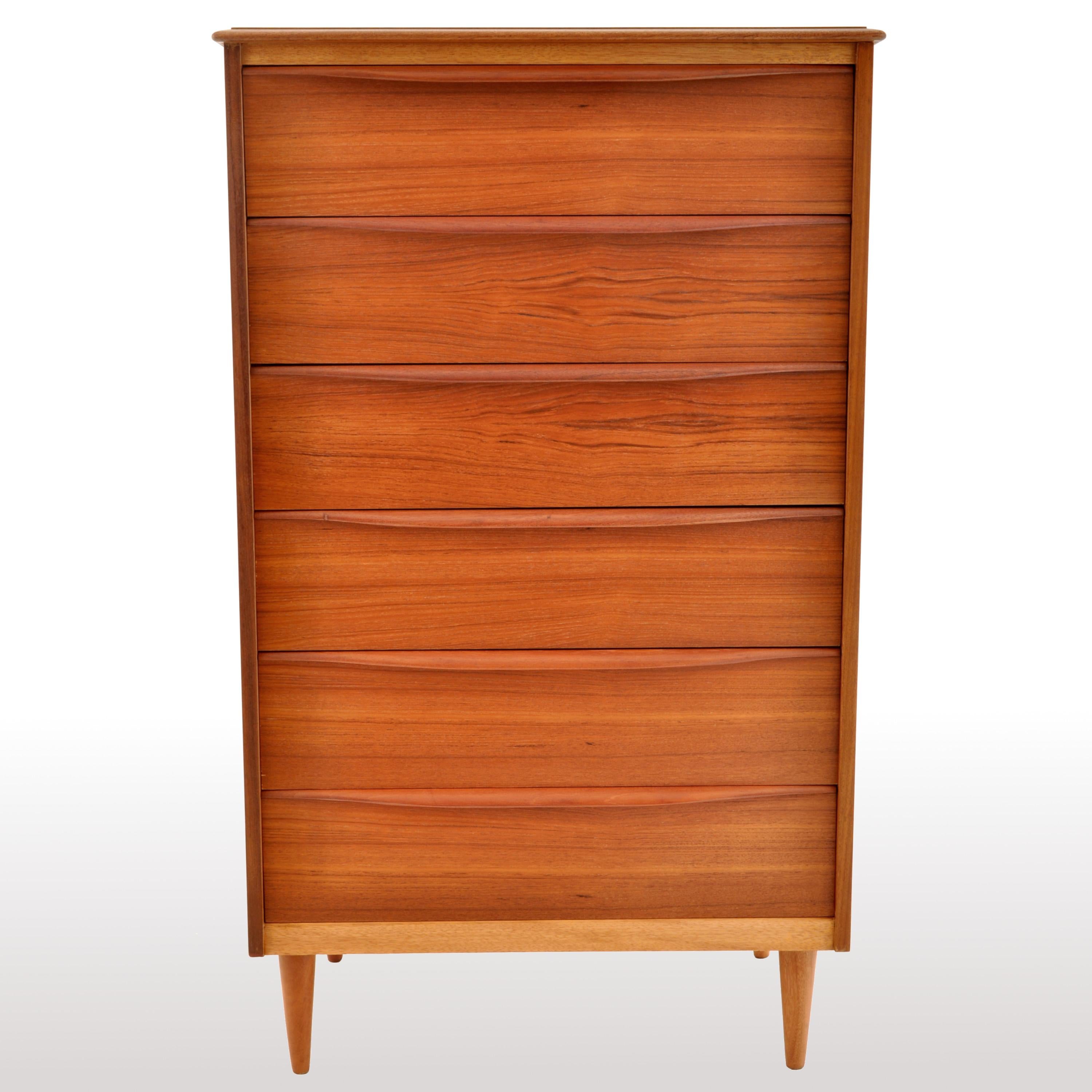 The dresser having six drawers with turned, elongated pulls and raised on round, tapering legs.