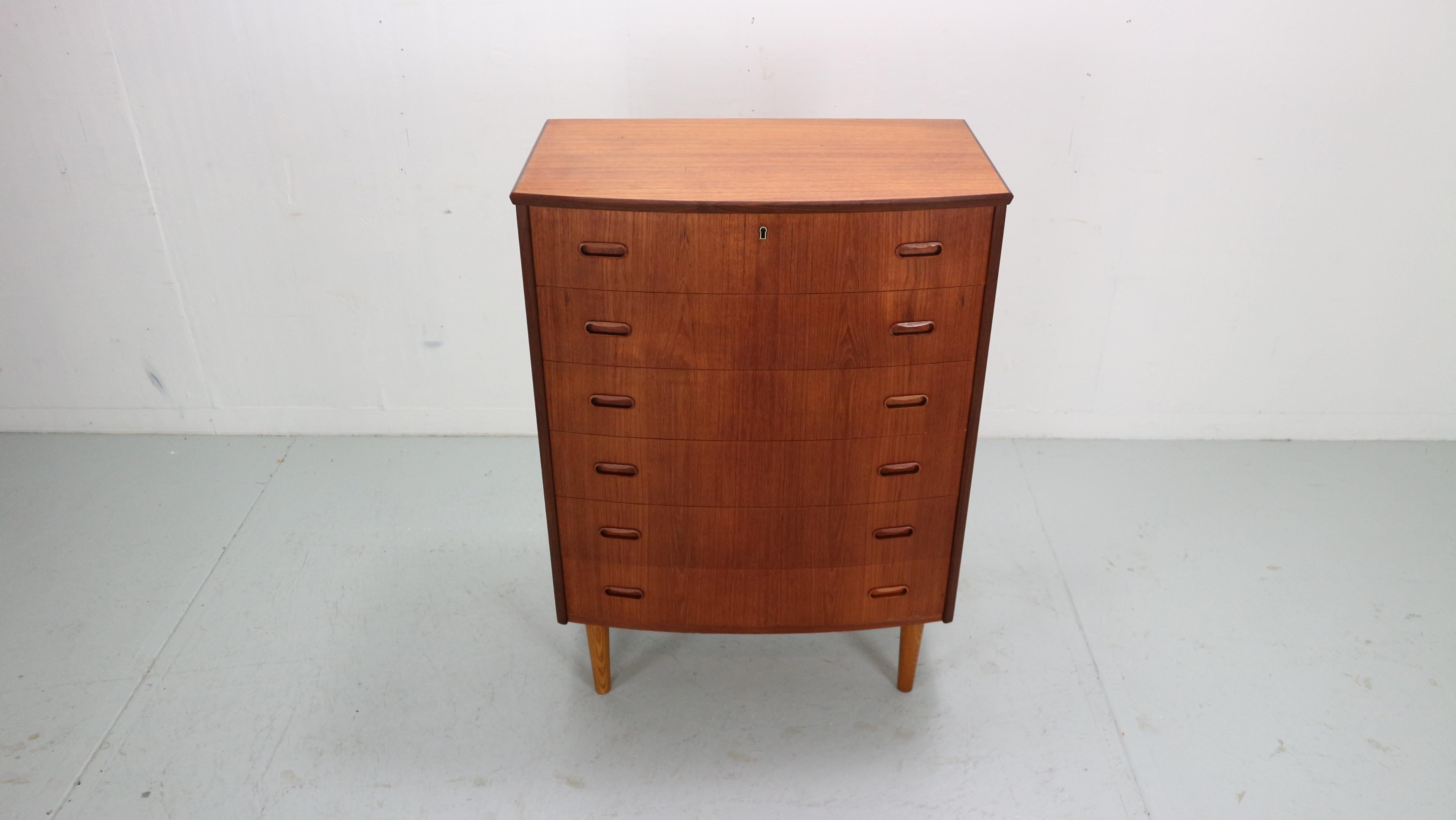 Mid- Century modern period chest of 6 drawers or tallboy cabinet made in 1960's Denmark.

Made of teak wood veneer. Elegant handles from both sides.
Original key with the working lock on the upper drawer.
Good working sliding drawers.
High quality