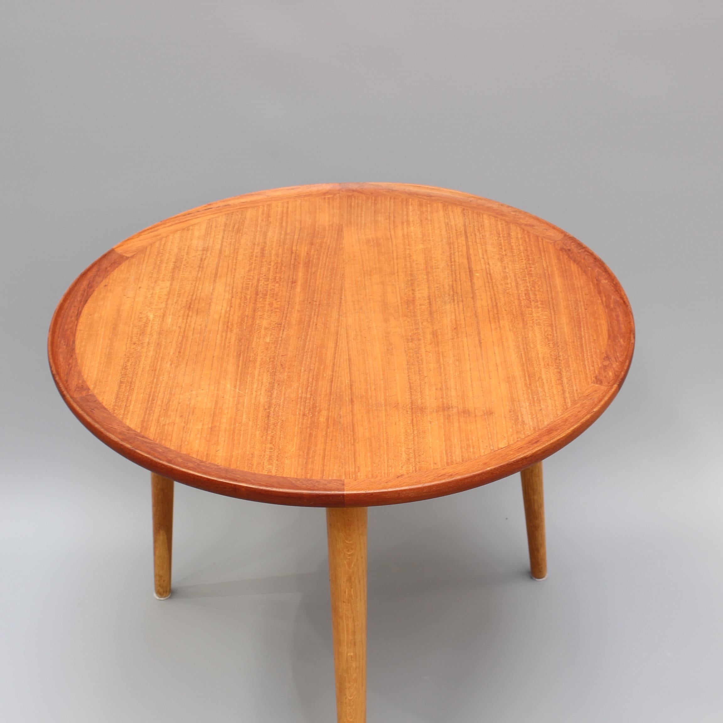 Mid-Century Modern Danish circular teak end table, circa 1960s. A sturdy, mid-weight, three-legged end table which is sure to be a conversation piece in any room in which it is placed. Commensurate with its age, there are characterful markings on
