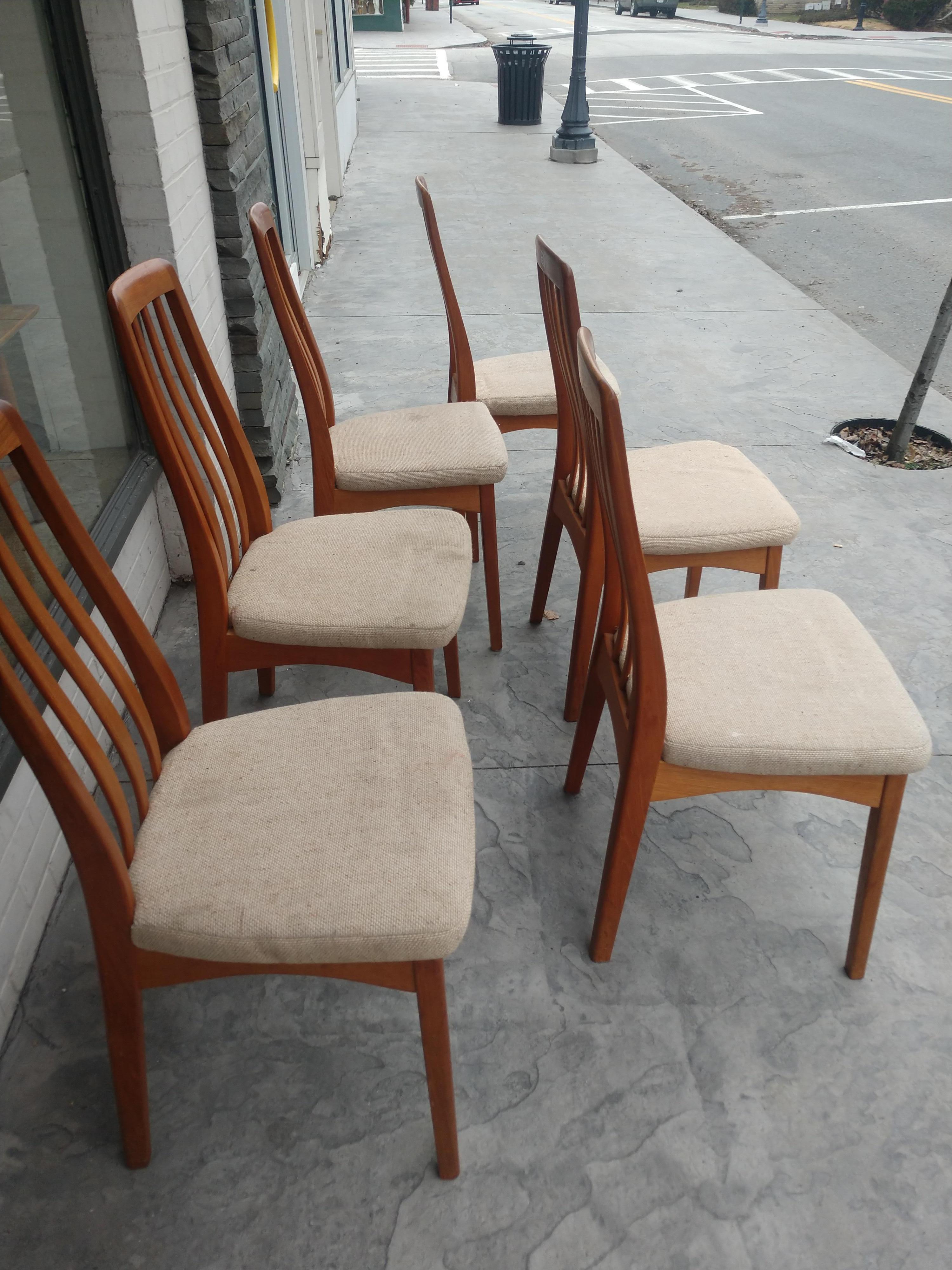 Simple and elegant set of 6 teak dining chairs by Benny Linden. Tall back chairs with curved slats in backs. Upholstered seats which need an upgrade. Teak frames are in excellent vintage condition with minimal wear. Sold as a set of six.