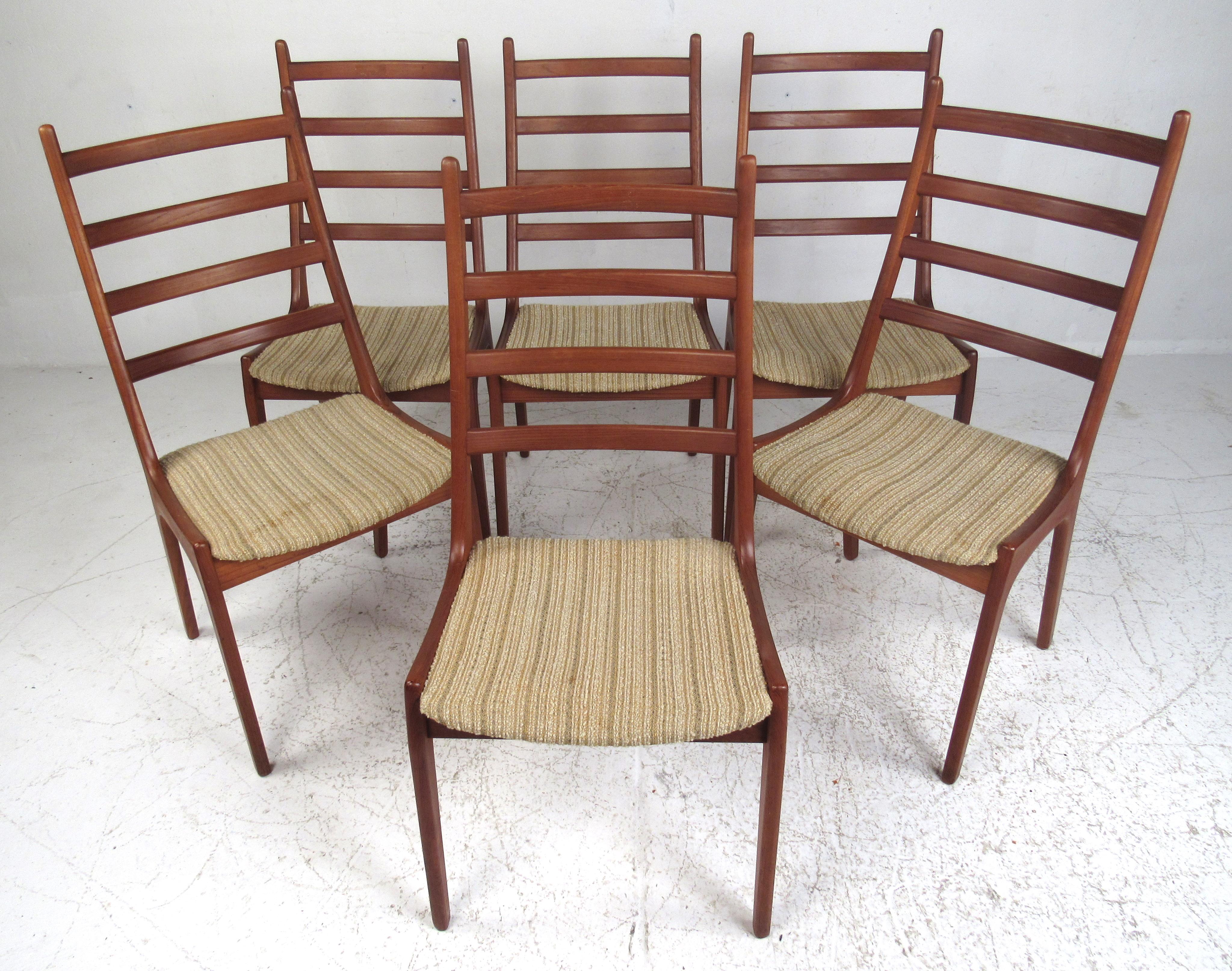 This stunning vintage modern dining set includes a set of six K.S dining chairs and a beautiful pedestal base dining table. A unique set of dining chairs with a ladder-back backrests, sculpted teak frames, and tapered legs. The oval top, pedestal