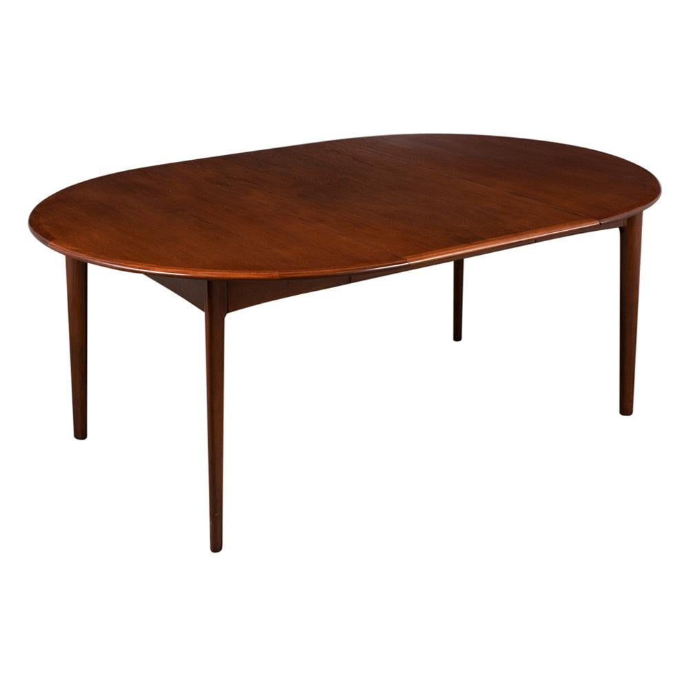 This Danish Modern Dining Table is made out of teak wood refinished in dark walnut color with a newly lacquered finish and been professionally restored. This Dining Table features a sleek design oval top shape two additional leaves and rests on four