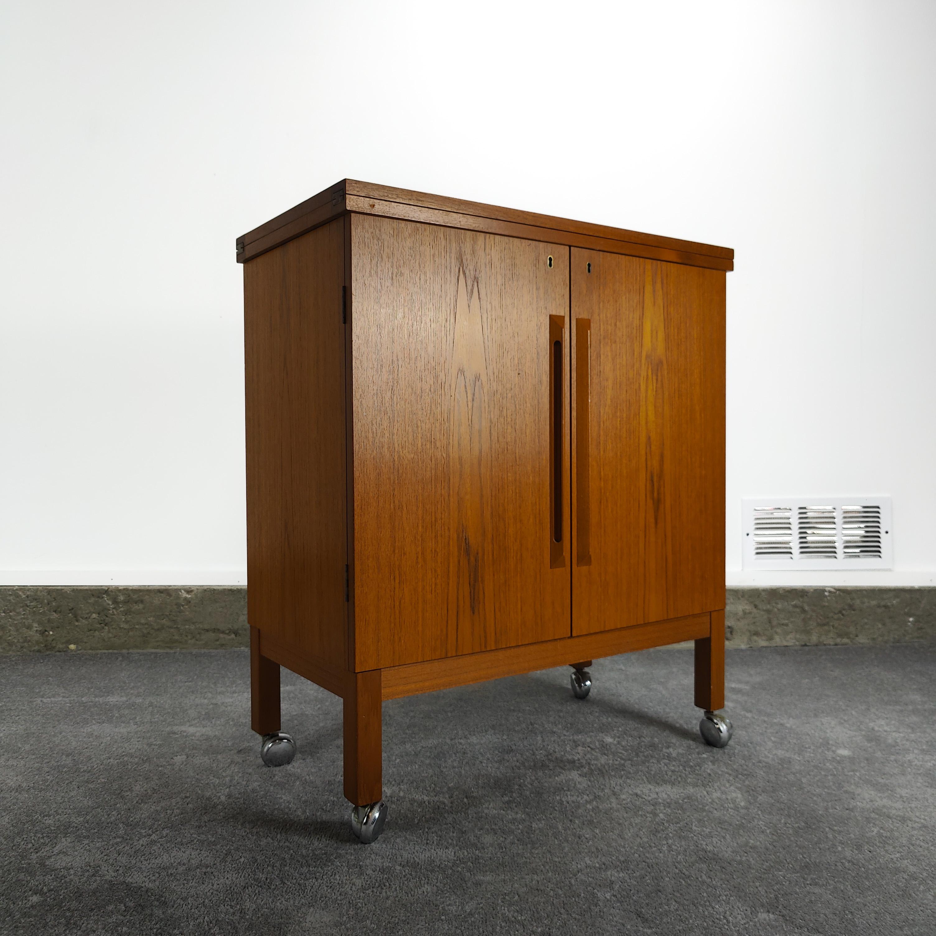 Now available, a versatile flip top bar cabinet designed by Torbjørn Afdal by Mellemstrands Møbelfabrik/Bruksbo in Norway, circa 1960s. Features a warm teak grain and clean with a solid surface black 