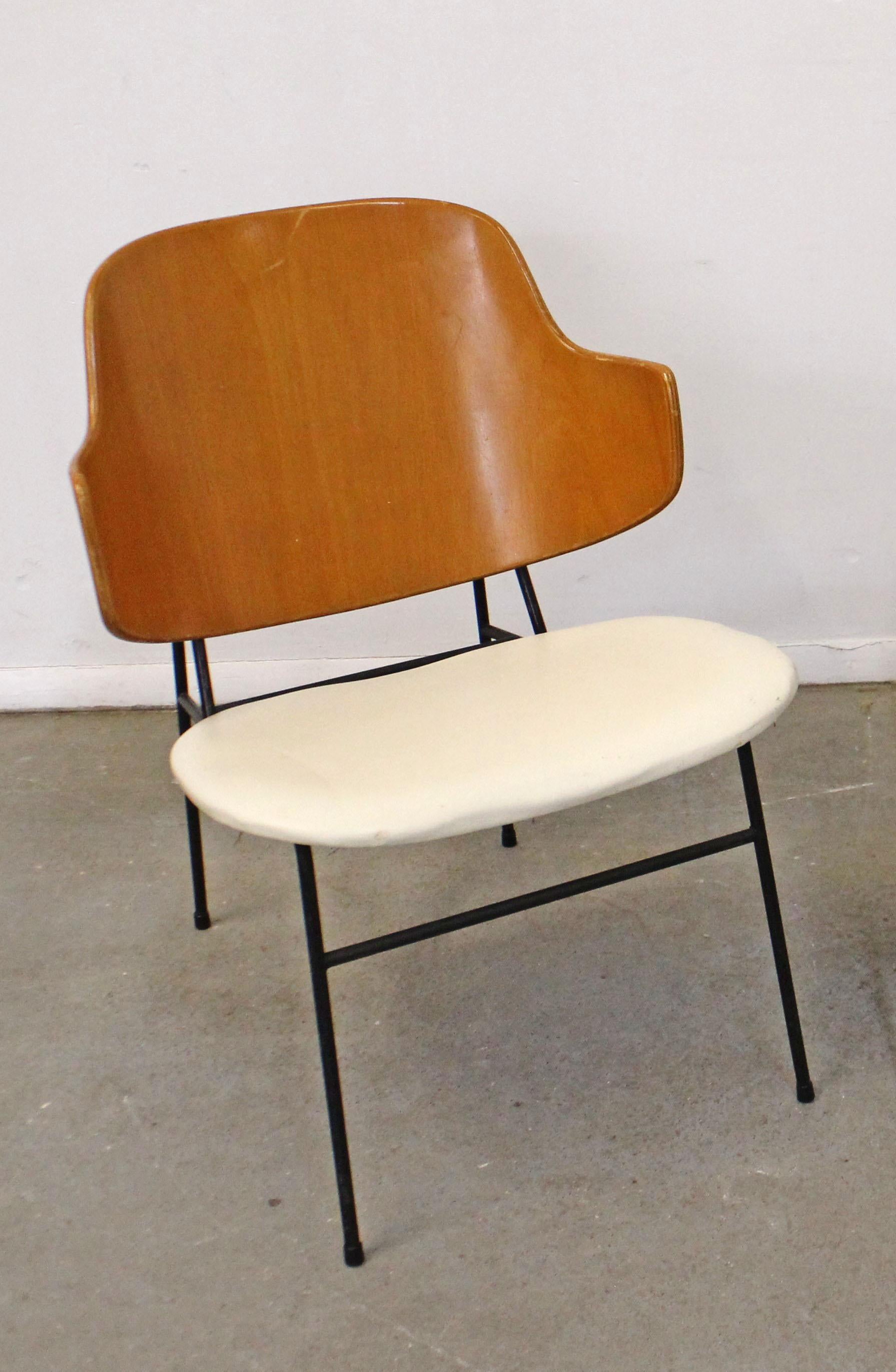What a find. Offered is an original 'Penguin' chair designed by IB Kofod Larsen for Selig. This chair was designed in 1953 and had a limited production through the 1960s. This chair has a metal base, wood back, and vinyl seat. In good, structurally
