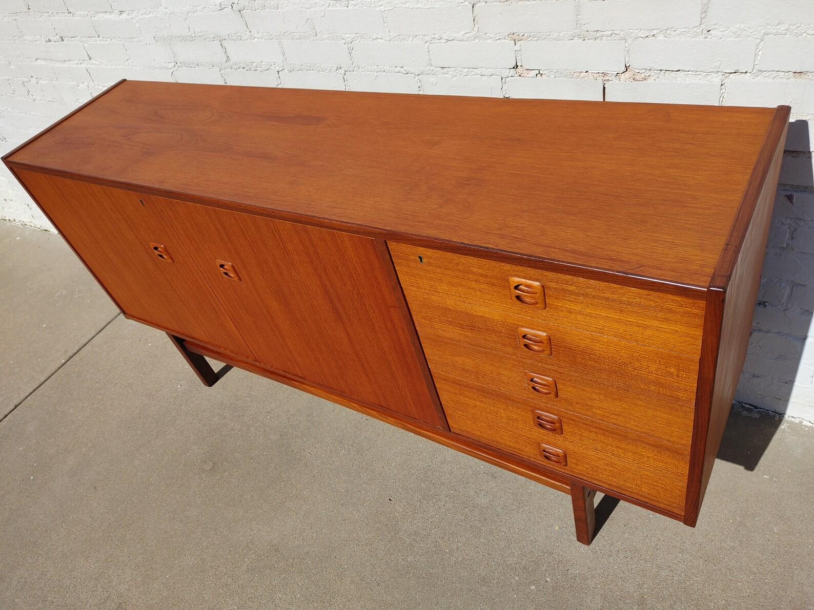 Mid Century Modern Danish Inspired Teak Cabinet

Above average vintage condition and structurally sound. Has some expected age-related finish wear and slight scratching.

Additional information:
Materials: Teak
Vintage from the 1960s
Dimensions: 67