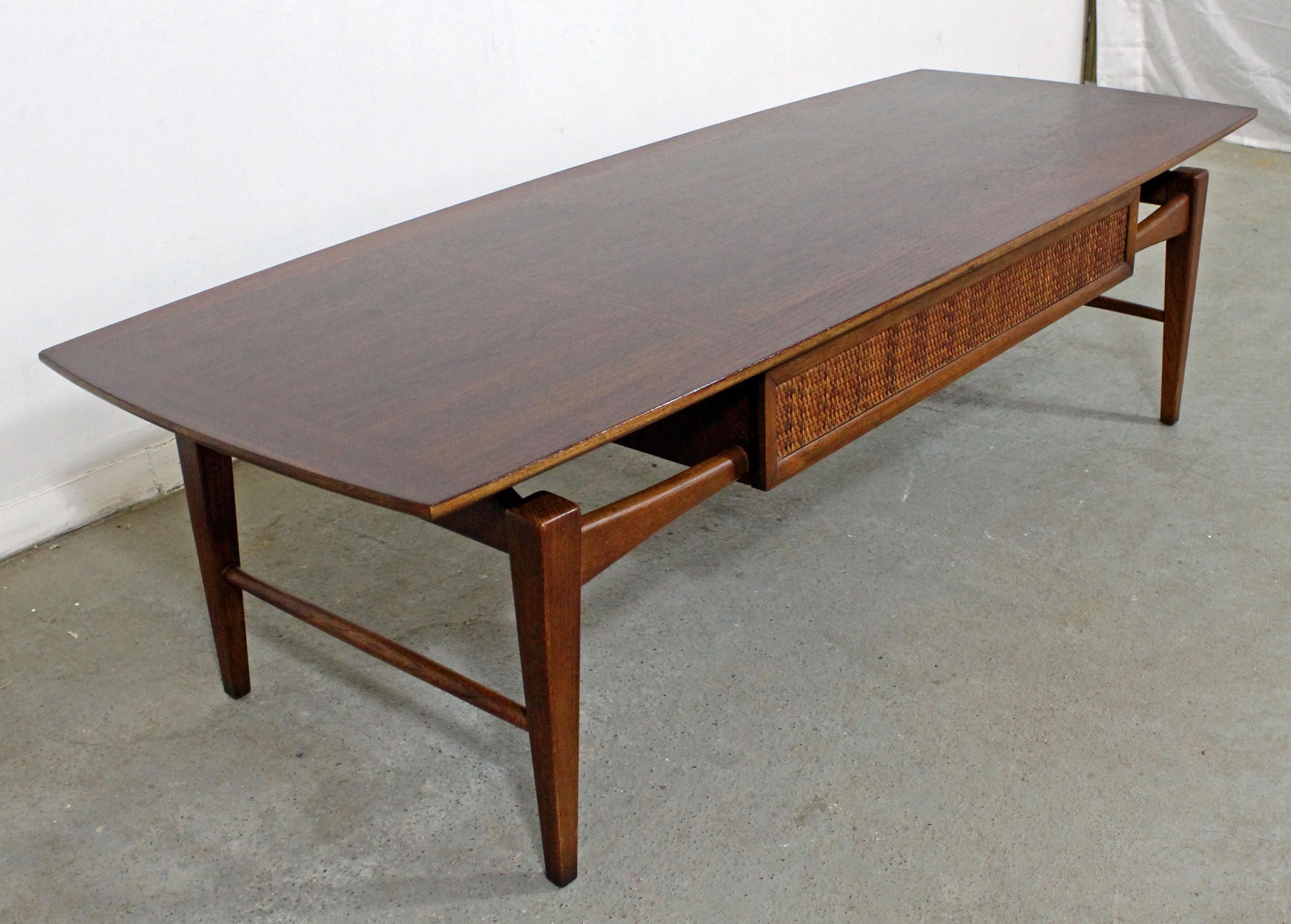 Offered is a Danish Modern-inspired modern coffee table by Lane Furniture's 'Esteem' line. This gorgeous walnut table gives the illusion of a floating top. Legs and stretchers are sculptured in the Danish fashion and the edges of the tops are