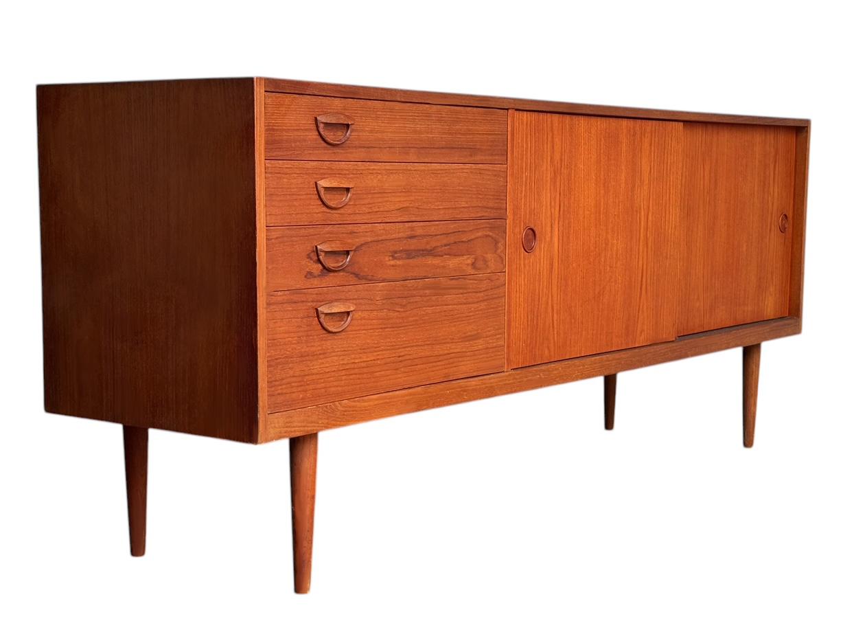 A beautifully designed teak credenza with top notch construction made by Kai Kristiansen. It features two cubicles with shelves and four drawers. Completely refinished condition.

