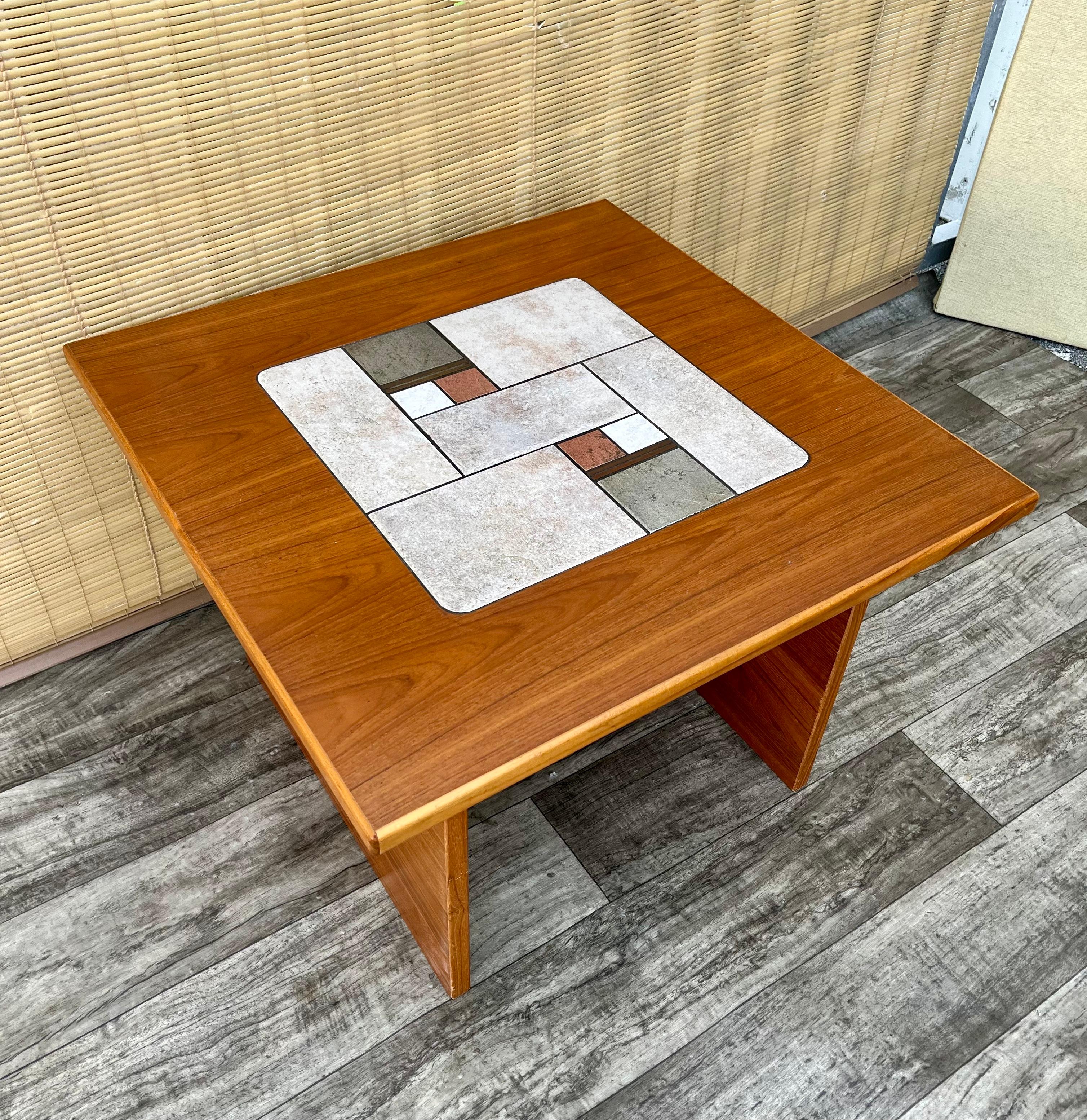 Vintage Mid Century Modern Danish Modern Tile Top Side Table. Circa 1970
Il présente un design moderne danois épuré avec une incrustation de carreaux de céramique d'inspiration brutaliste et un magnifique grain de bois.
En excellent état, proche de