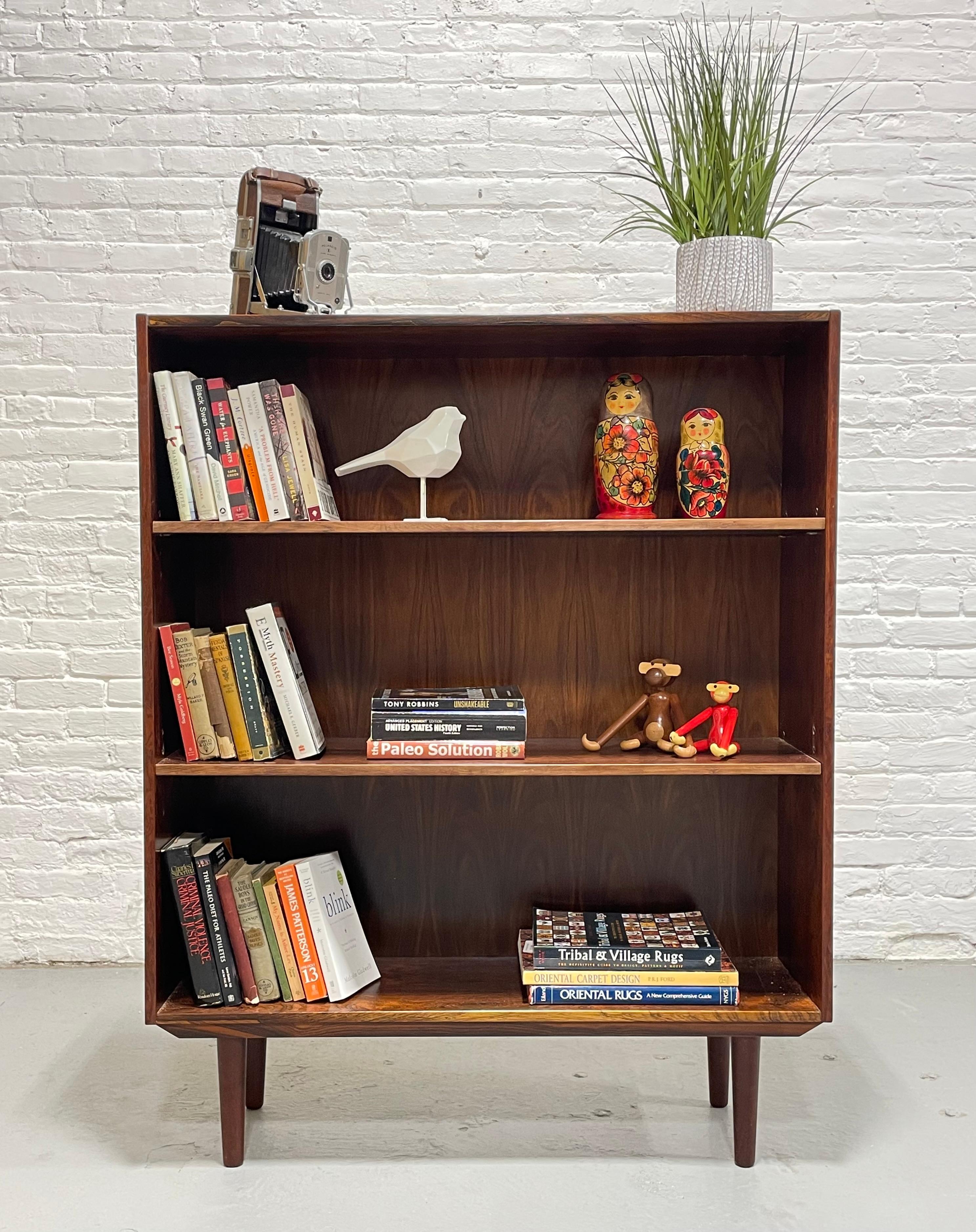Simple + Classic Mid Century Modern ROSEWOOD bookcase, c. 1960's. This stunning piece features three wide and long shelving areas and all shelves are removable and adjustable.  Gorgeous wood grains - constructed in rosewood and its deep, rich color