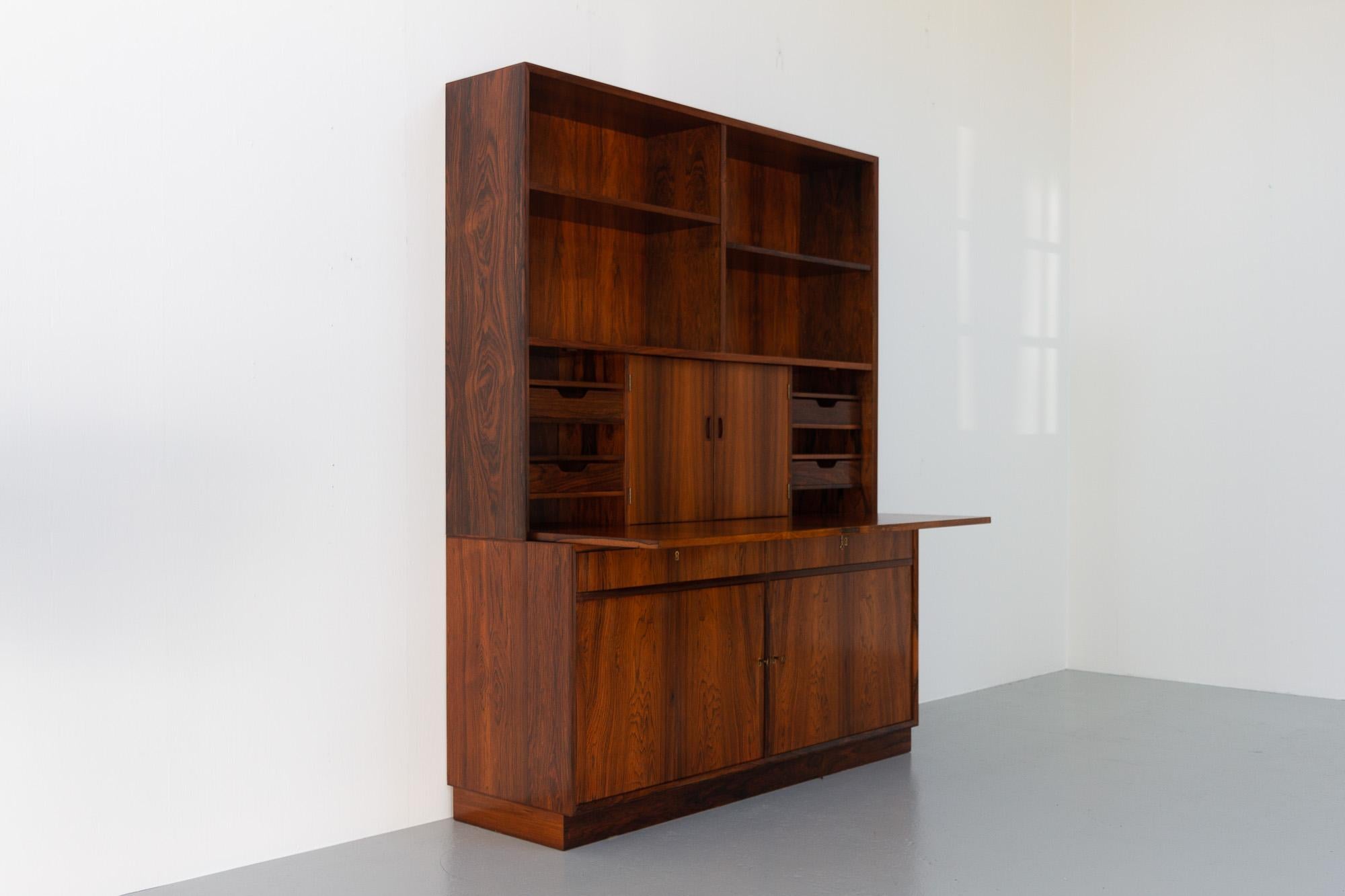 Mid-Century Modern Danish Rosewood Bookcase with Desk, 1960s.
Beautiful and elegant Scandinavian Modern two part bookcase. Lower sideboard with two drawers and two hinged doors offers loads of storage space. Upper part with drop down door behind