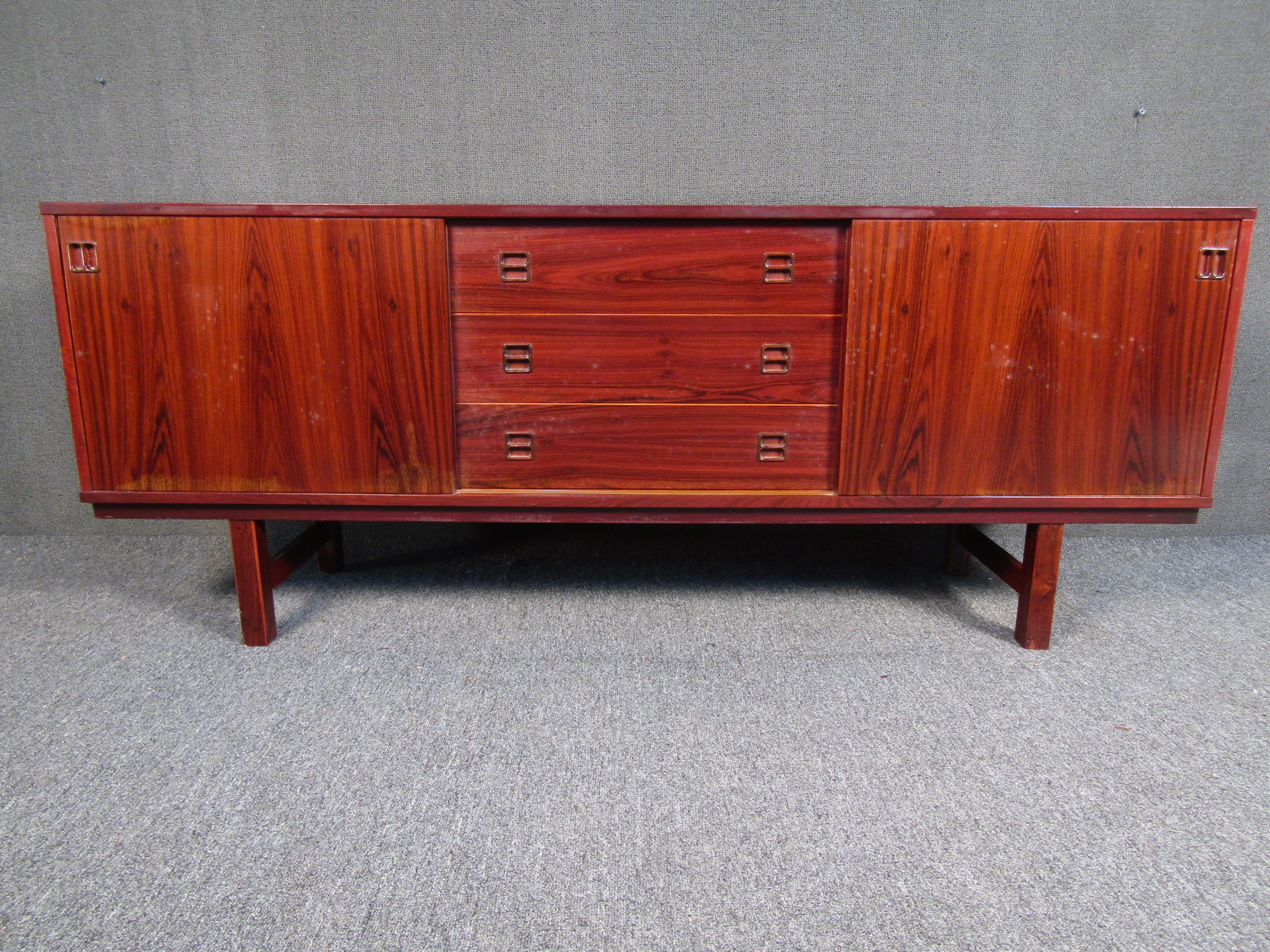 A stunning Mid-Century Modern Danish rosewood credenza. A unique dresser with sliding doors and 3 drawers for optimum storage. Its sleek design is perfect for any home/office/bedroom setting. 

Please confirm pickup location with seller (NY/NJ).