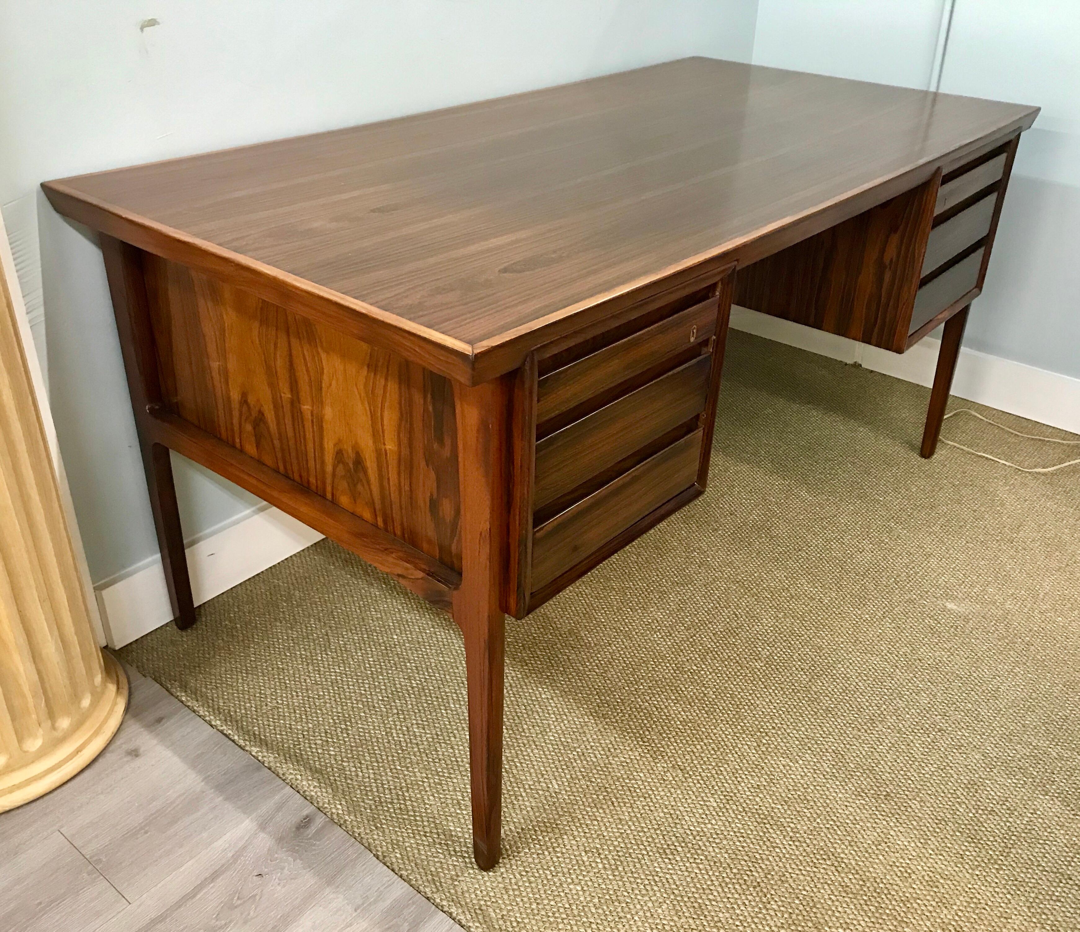 Sleek Danish modern rosewood desk that has the most perfect of lines. No manufacturer's hallmarks and although there are locks to drawers, it does not come with keys.