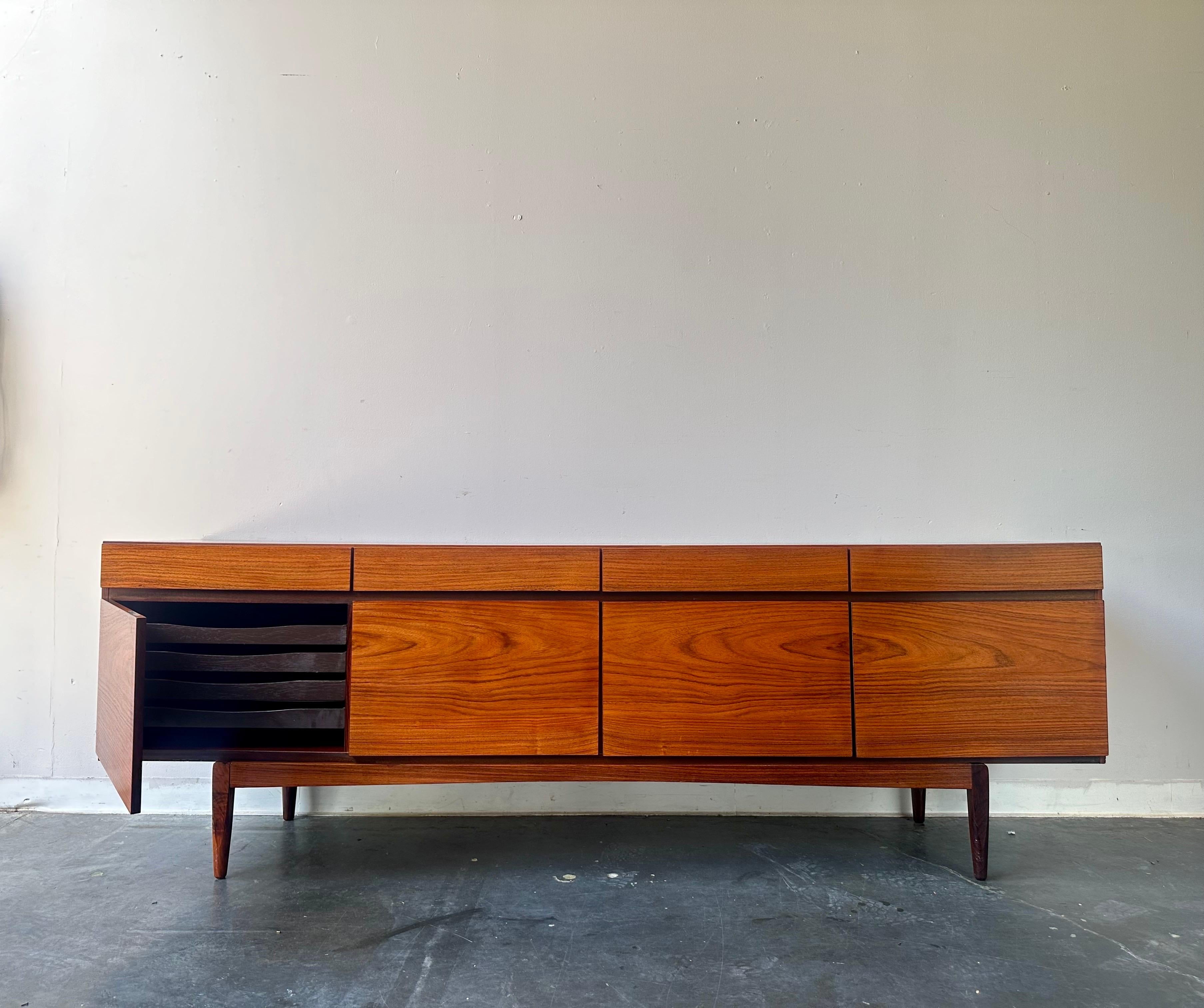 Exquisito y raro aparador moderno de mediados de siglo fabricado en precioso palisandro de la India, por el renombrado diseñador Kofod Larsen. El palisandro de la India es un palisandro de calidad que resiste el paso del tiempo y se aclara con la