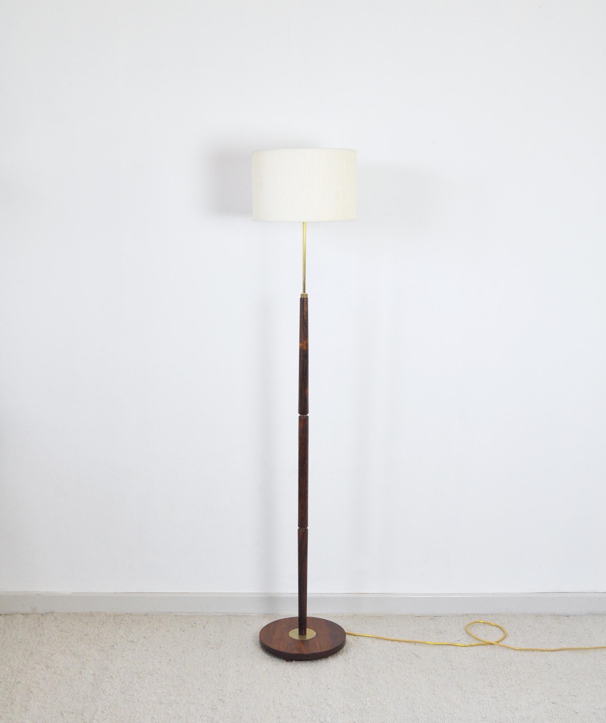 Mid-Century Modern rosewood floor lamp with brass details. 
Denmark the 1960s. 
Item comes without shade.

Measures: Lamp base diameter 28 cm
Height 140 cm to socket.
