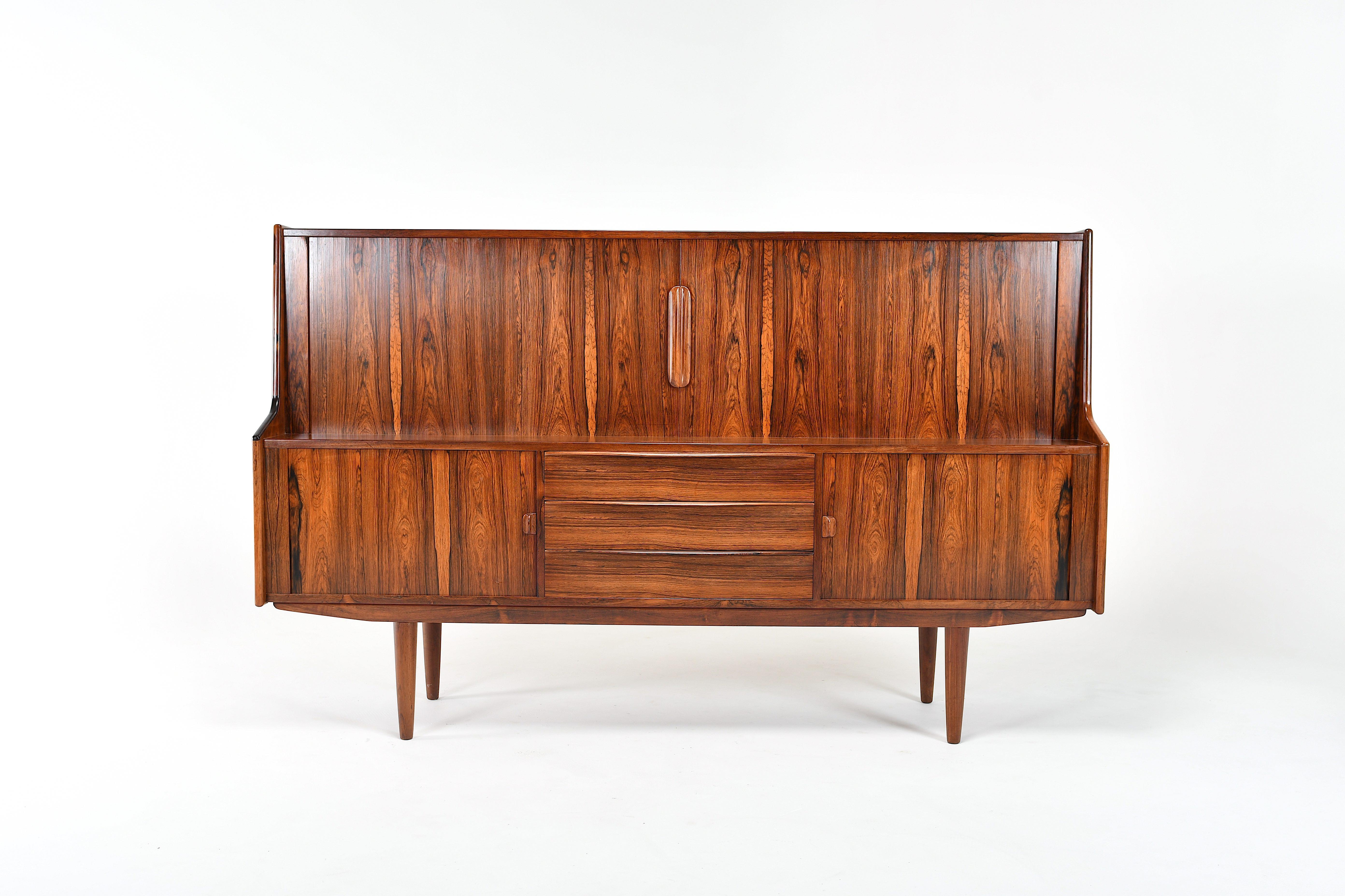 Mid-Century Modern Danish highboard designed by Ib Kofod Larsen for Faarup.
The top has two tambour doors opening on two shelved spaces and four drawers in the middle.
The bottom has two tambour doors and three drawers in the middle.
Very good