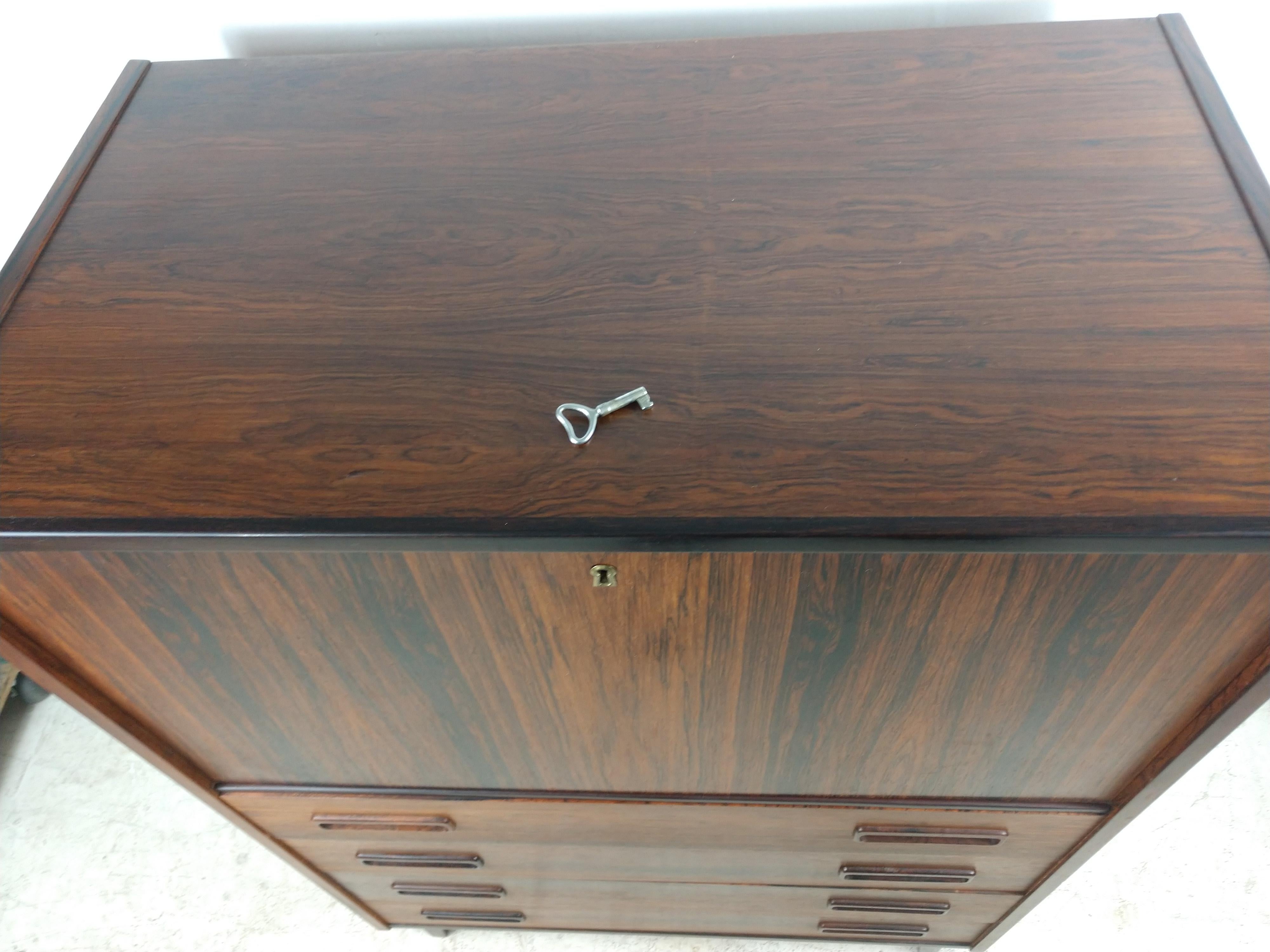 Simple and elegant secretary desk with 4 drawers below the drop down desk lid. Desk opens to reveal 3 small drawers and 2 shelves for storage. Beautiful rosewood graining throughout the piece. Drawers all glide effortlessly. Original key and lock