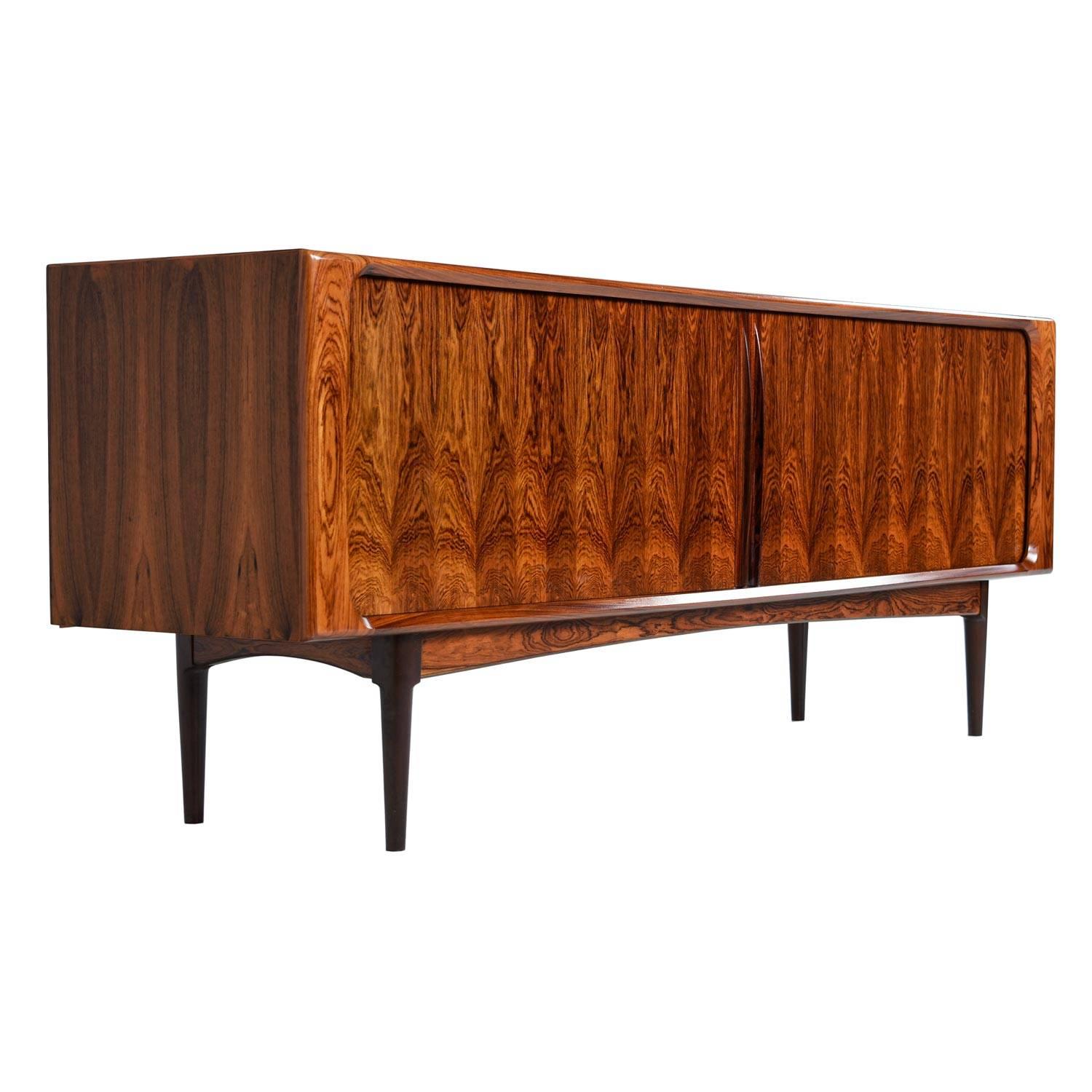 Near mint condition, long Mid-Century Modern Danish teak credenza by Bernhard Pedersen. The natural beauty of the rosewood pattern on the tambour doors is something we rarely see in the caliber. It's truly stunning. 

Expertly crafted with sleek