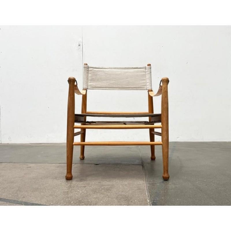 Mid Century Safari Chair from the Danish manufacturer Farstrup.

A minimalist design. The backrest and seat are made of a light canvas material. The solid wood frame can be dismantled to a certain extent. The leather straps of the armrests are