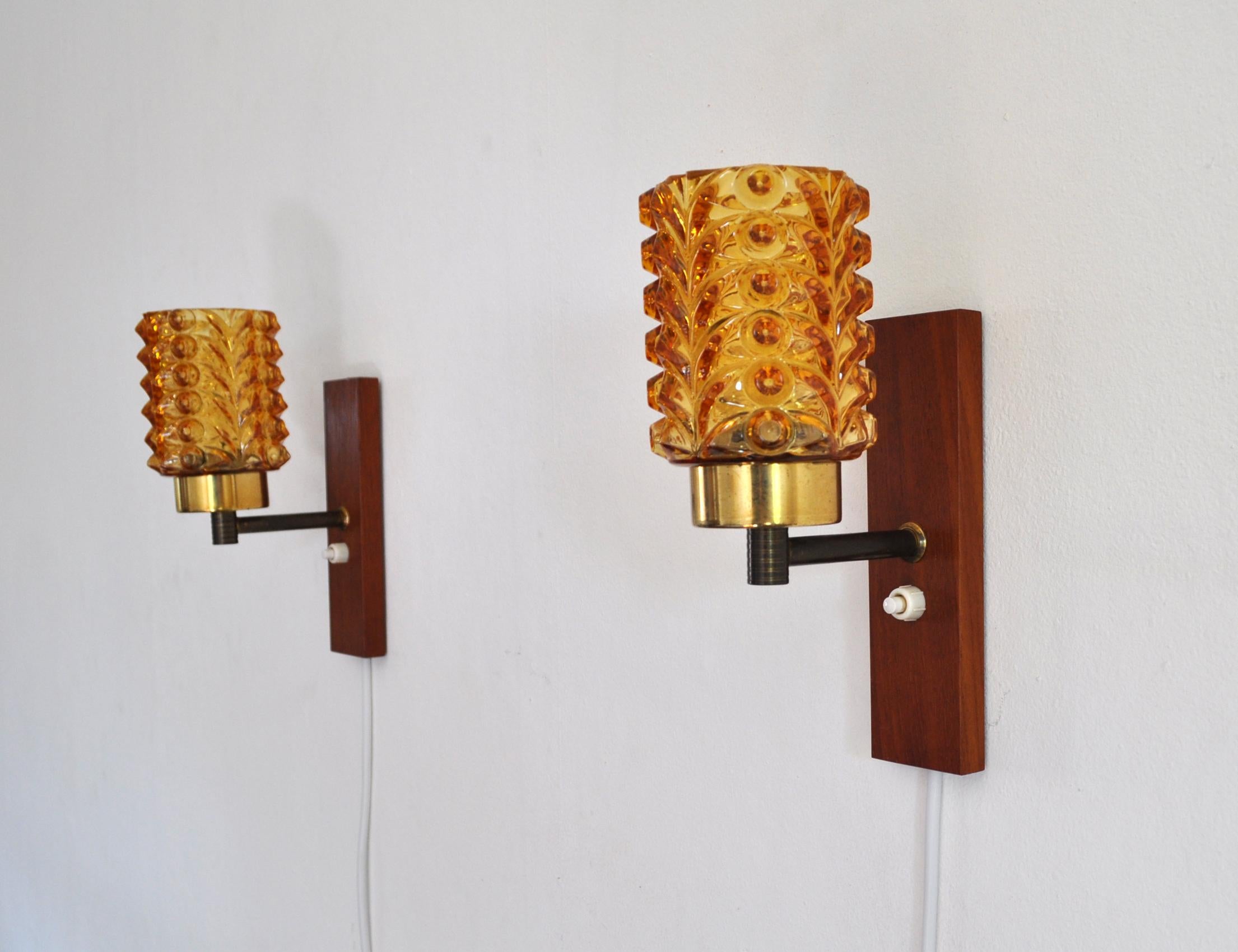 Mid-Century Modern pair of wall lights in solid teak, brass and amber colored glass shade, Denmark the 1950s.
Very good vintage condition.

Dimensions:
Height: 20 cm
Width: 7.5 cm
Depth: 12.5 cm
Glass shade: diameter 7.5 cm, height (visible
