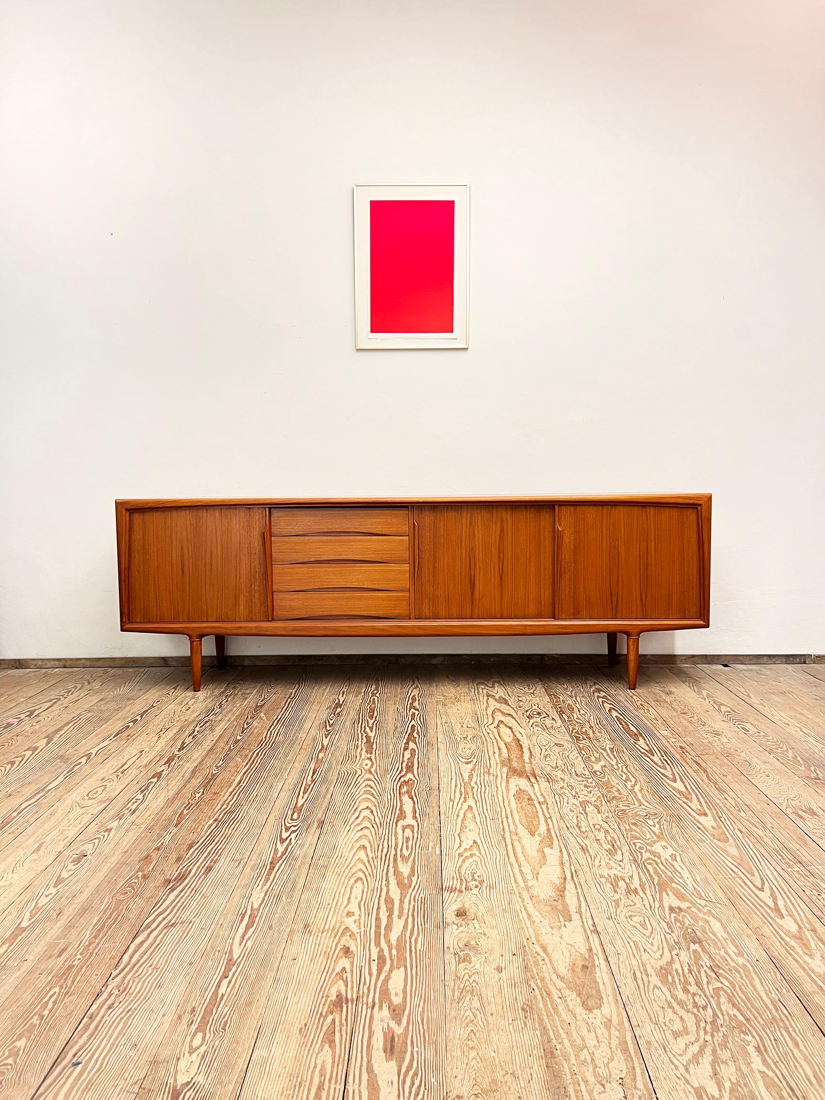 Dimensions: 240x47x80 cm (Width x Depth x Height)

This Scandinavian mid century modern teak credenza was manufactured in the 1950s by Axel Christensen Odder or ACO in Denmark.

It shows exquisite Danish craftsmanship and offers plenty of storage