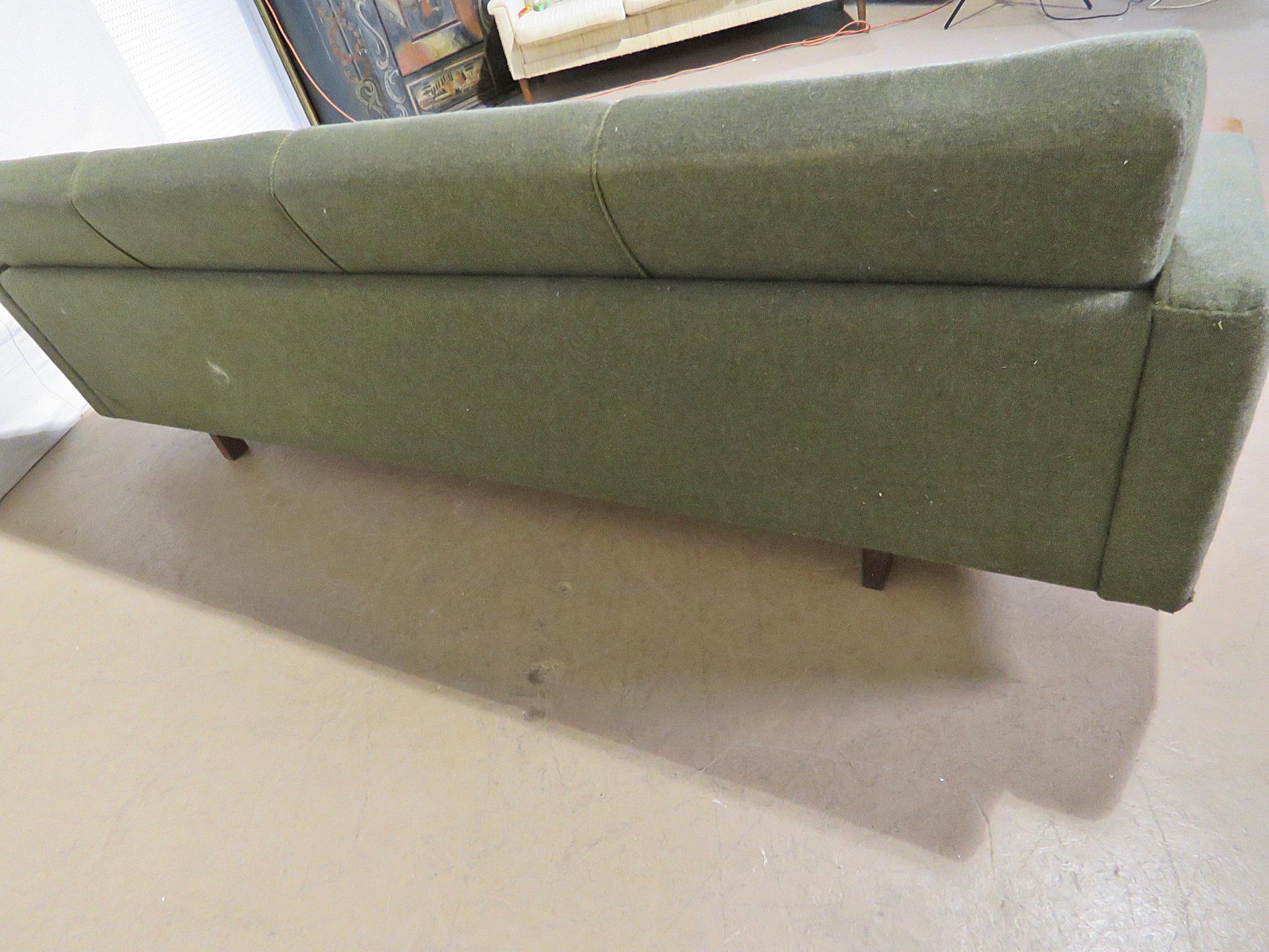 Vintage Mid-Century Modern sofa with piping to the upholstery.