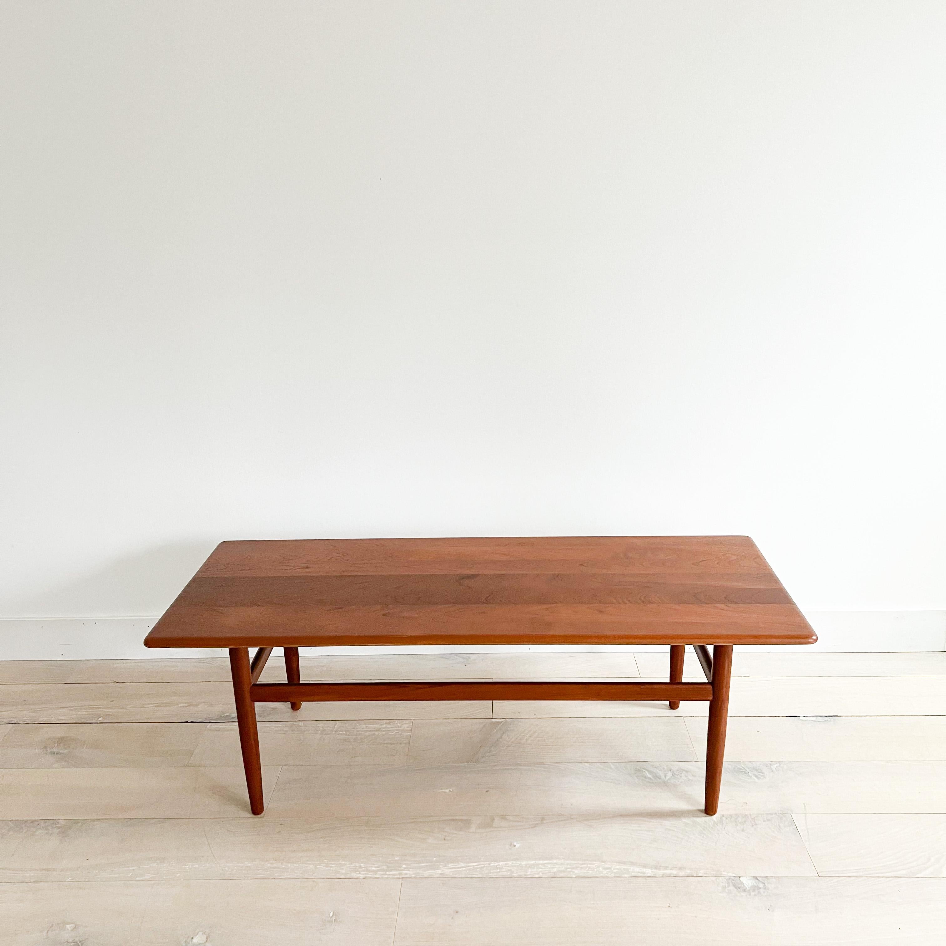 Mid century modern danish solid teak coffee table on tapered legs. The top has been sanded and restored. Some light scuffing/scratching from age appropriate wear. Stamped Made in Denmark

56.5”x23.5” 19”H