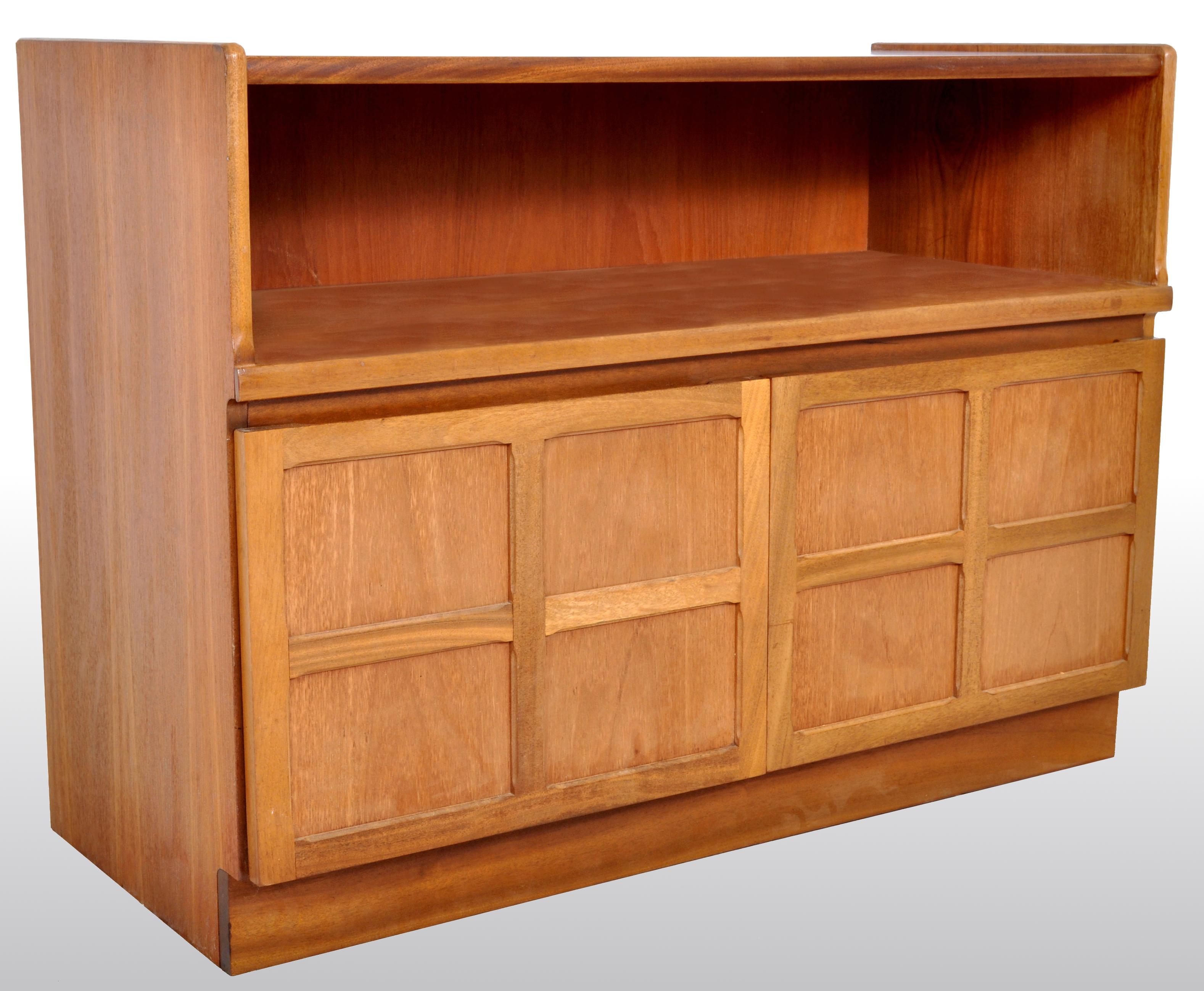 Mid-Century Modern Danish style media cabinet in Teak by Nathan Furniture, 1960s. The cabinet having a recessed cavity above twin paneled cupboard doors and standing on a plinth base. The cabinet bearing the original 