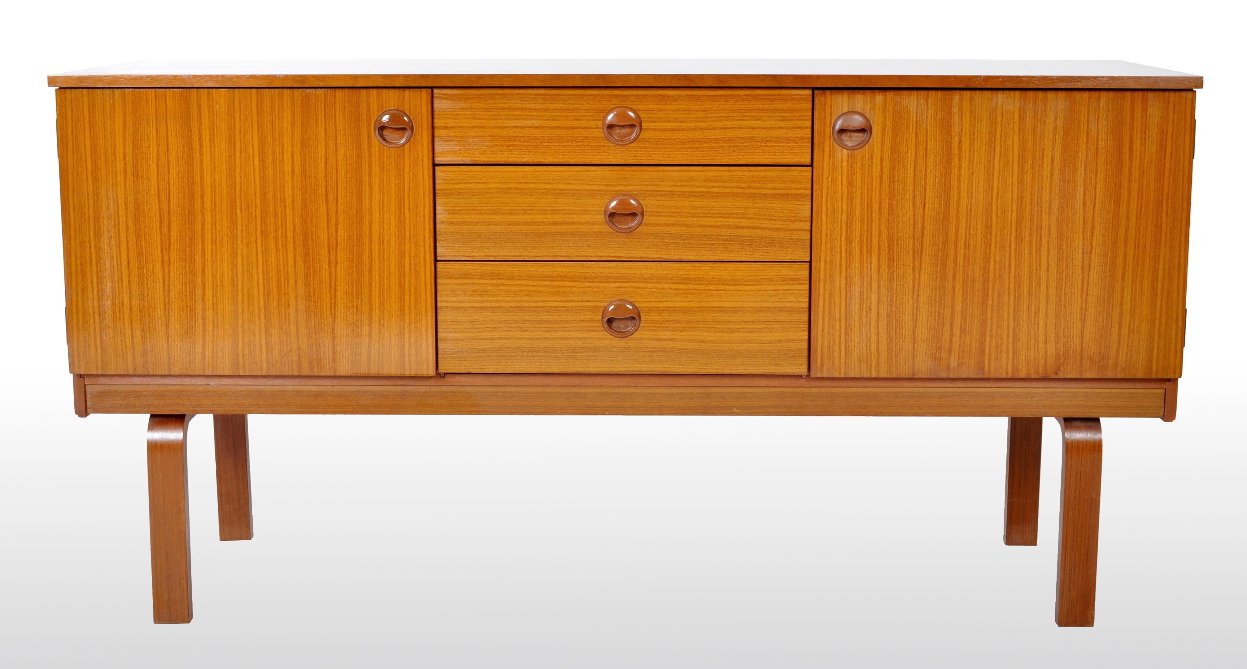 The credenza having twin cupboards at each side and a bank of three graduated drawers to the center. The credenza is raised on curved bentwood legs, having the 