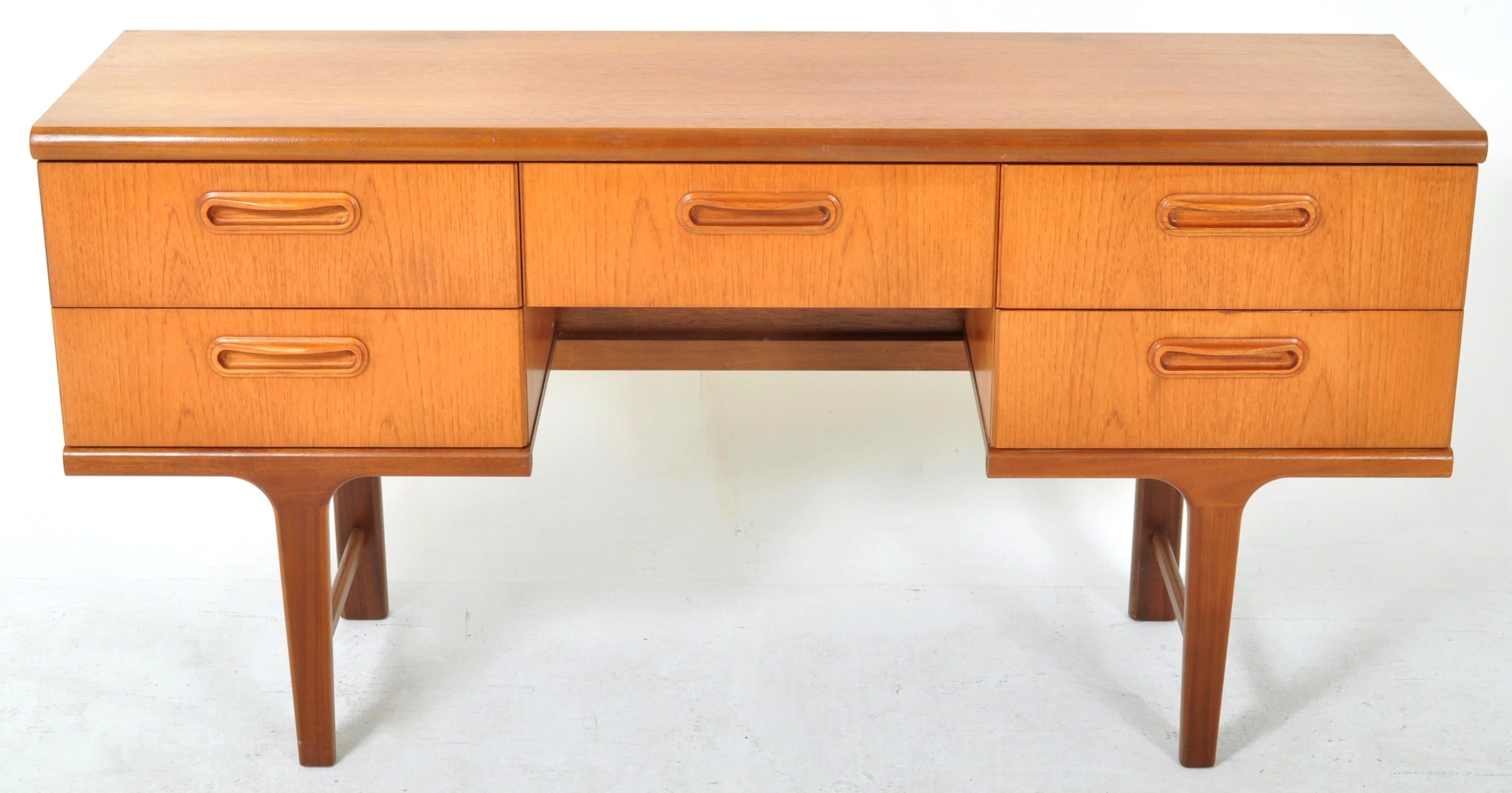 Mid-Century Modern Danish style teak desk, 1960s. The desk of twin pedestal form with a central knee-hole with a single drawer above and flanked on each side by a pair of drawers. The desk standing on gently tapered legs joined by cross stretchers.
