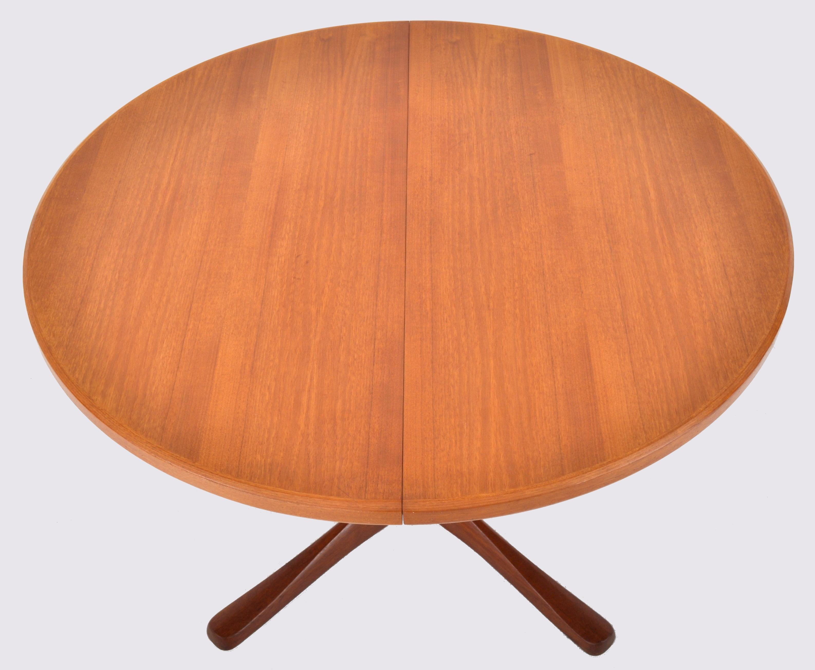 Mid-Century Modern Danish style teak dining table with twin leaves by McIntosh, 1960s. The circular table standing on twin pedestals with 'whale tale' legs, the table opens to receive two leaves. The table signed with the McIntosh tag to the