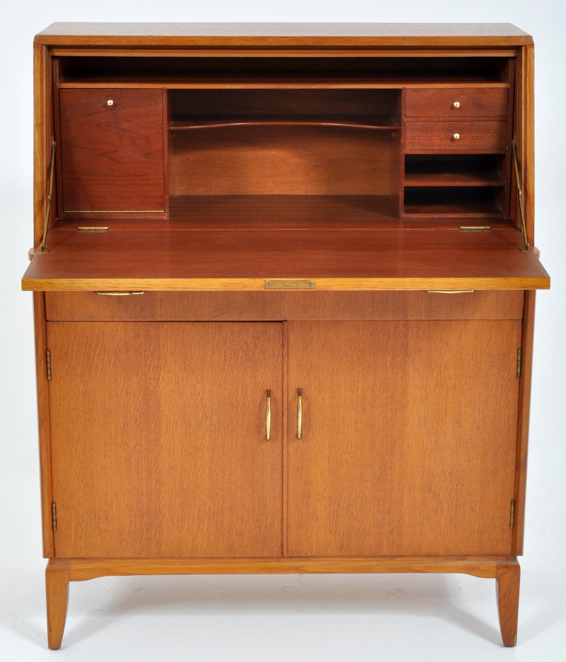 Mid-Century Modern Danish style teak secretary desk or cabinet by Lebus Furniture, 1960s. The cabinet having a fall front secretary enclosing a fitted interior. Below a central drawer above a cupboard of two doors enclosing a single shelf, the