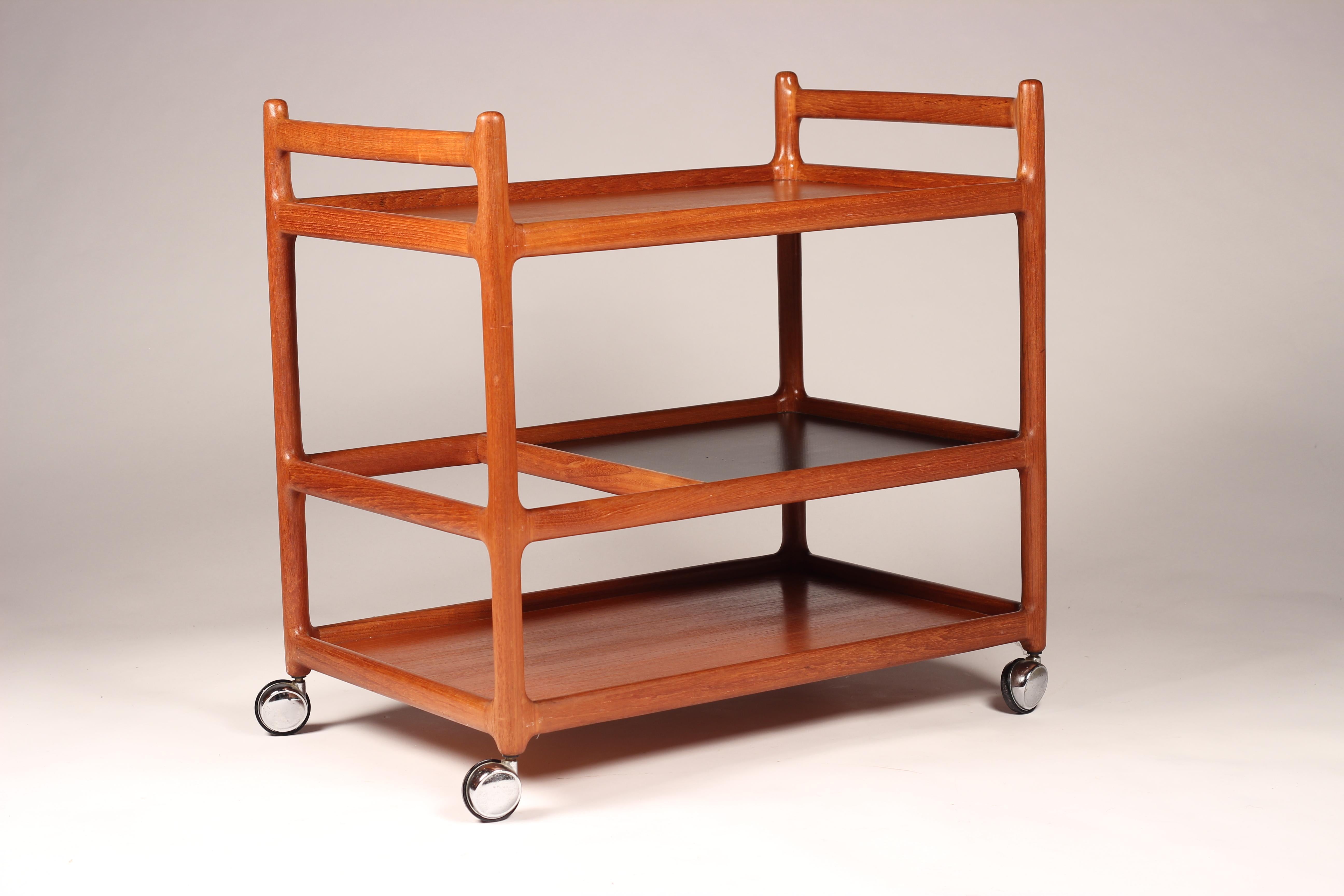 Elegant and simply designed Danish bar cart on gliding wheels. Beautifully detailed wooden joints and structure that encourages you to use all three levels, the middle one not only leaves one end for double height items, but also has a black