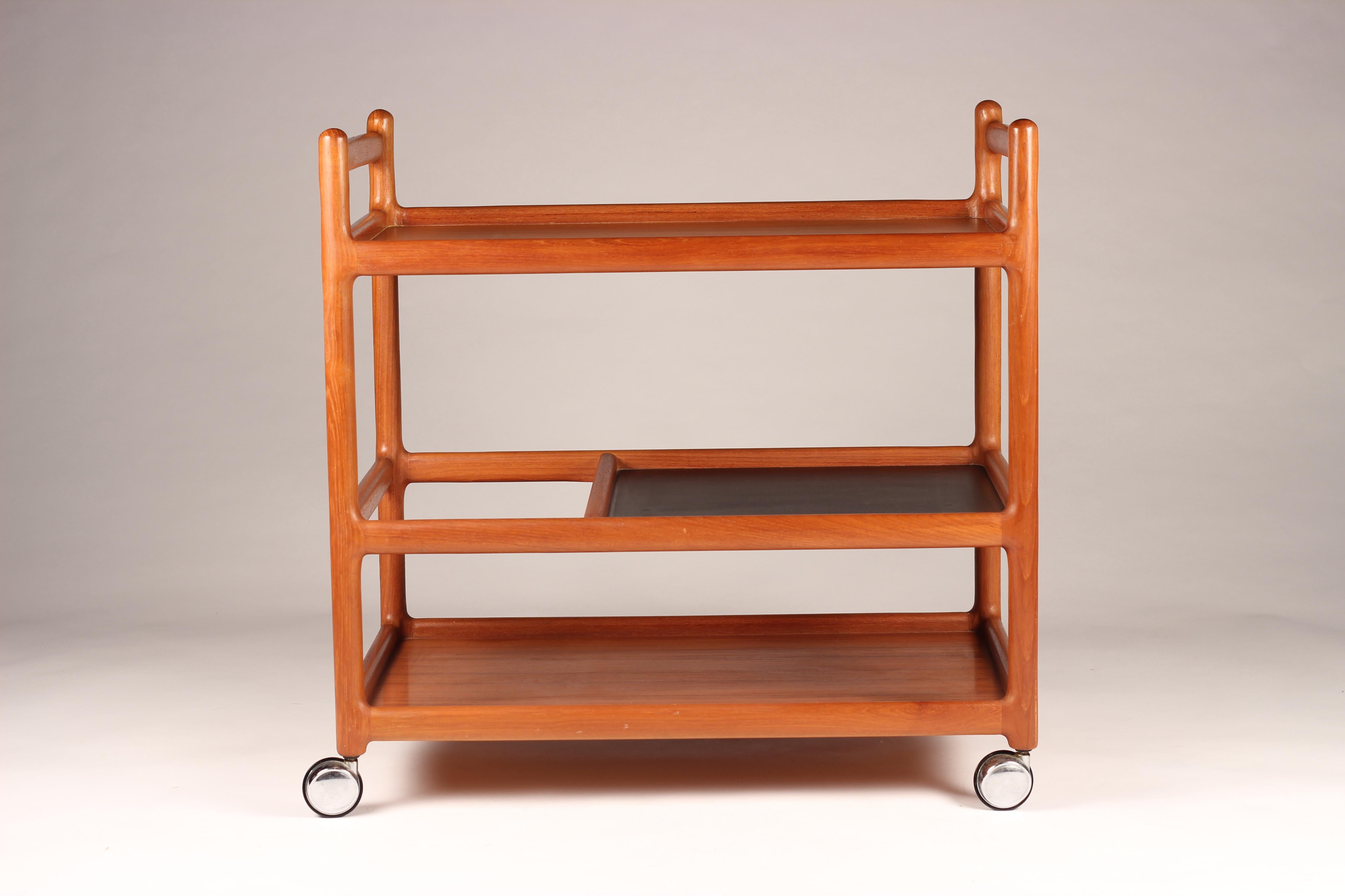 Elegant and simply designed Danish bar cart on gliding wheels. Beautifully detailed wooden joints and structure that encourages you to use all three levels, the middle one not only leaves one end for double height items, but also has a black