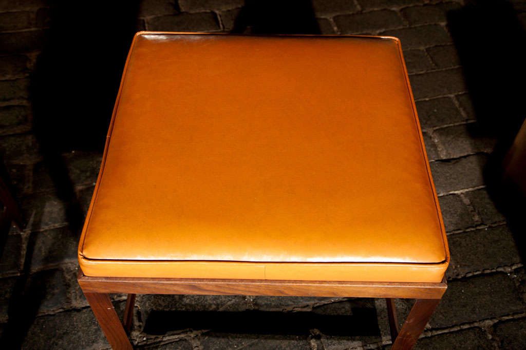 Simple rectilinear shaped bench with original orange vinyl cushion from the 1960s.